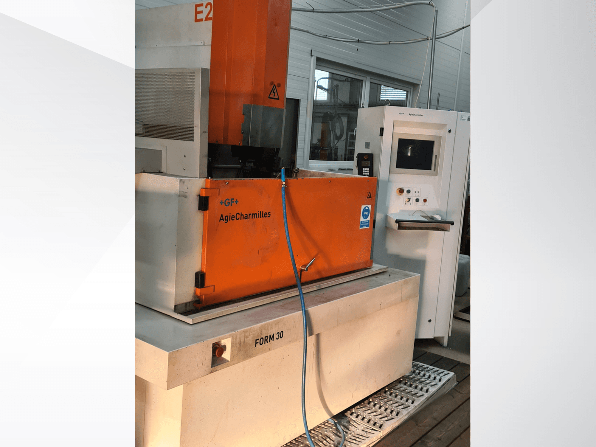 Machine d'électroérosion par enfonçage AgieCharmilles FORM 30, vue de face, avec l'armoire de commande orange et le tuyau d'eau visibles.