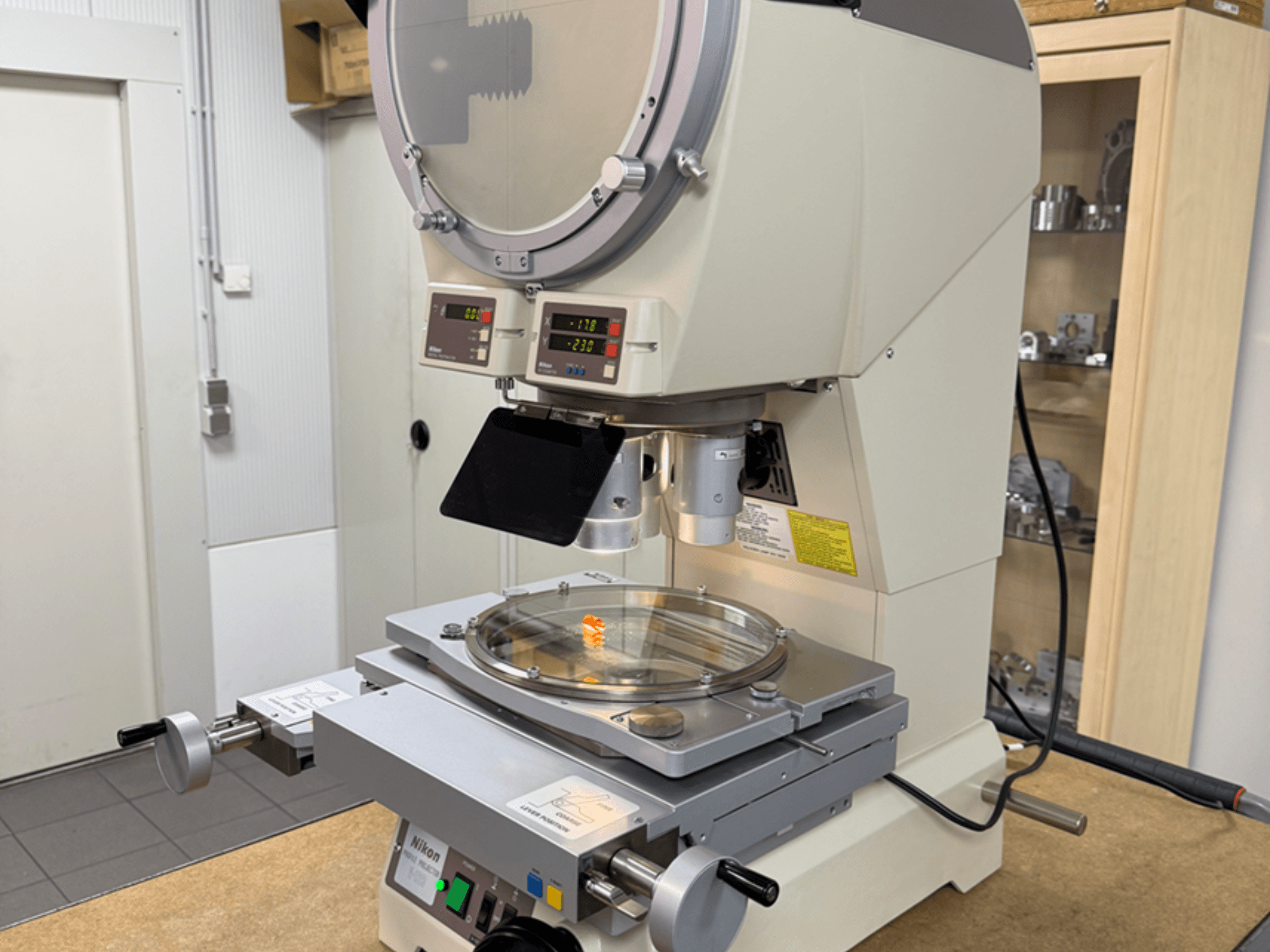 Microscope modèle Nikon vu de face, doté d'écrans numériques, d'une platine réglable et d'une plaque de verre circulaire.