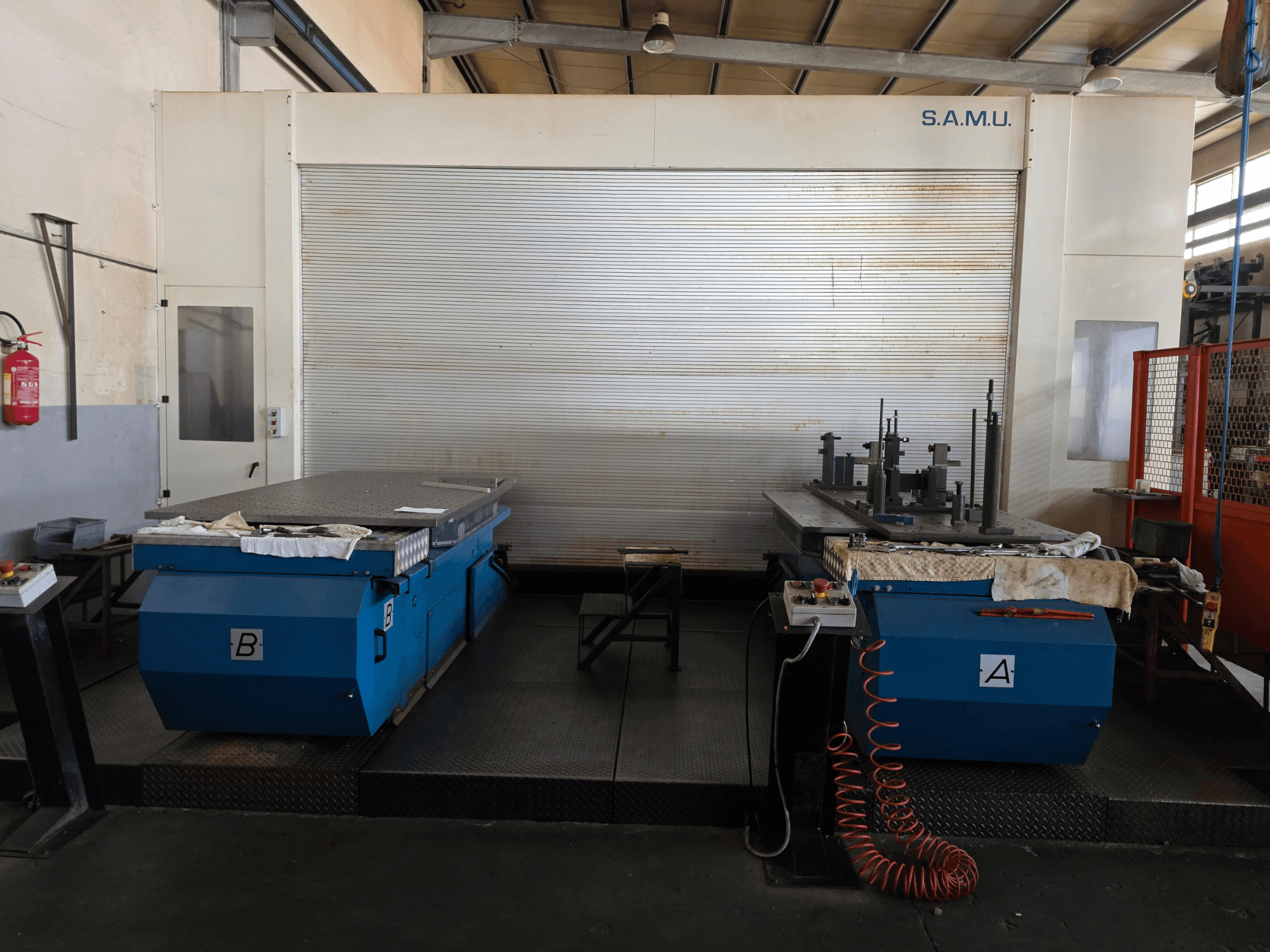 Centre d'usinage horizontal Mandelli RS1500 U25 vu de face, équipé de deux tables de travail bleues portant les lettres A et B.