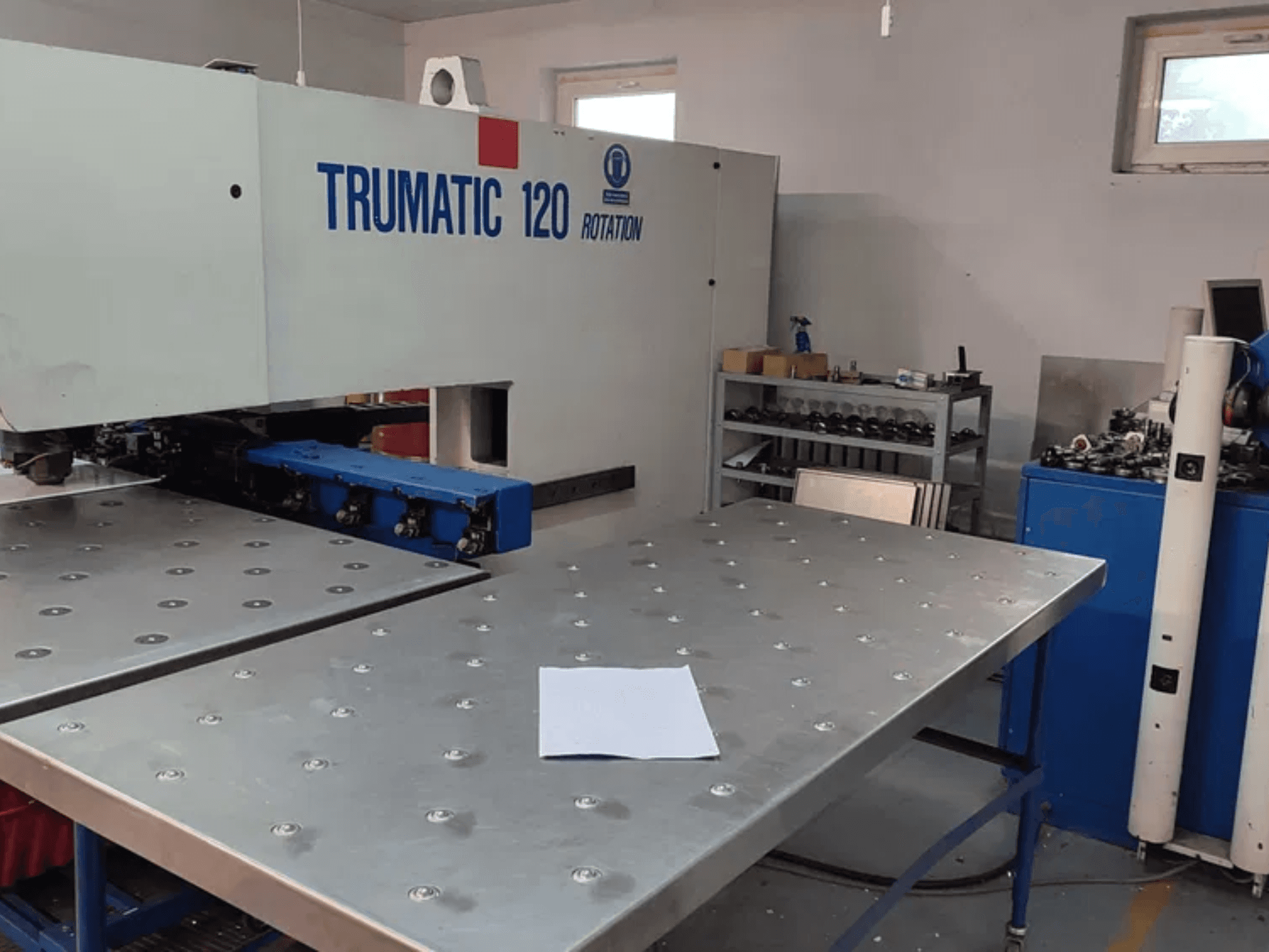 Poinçonneuse TRUMPF TRUMATIC 120R CNC vue de face, présentant une table métallique avec des trous perforés et une feuille vierge.