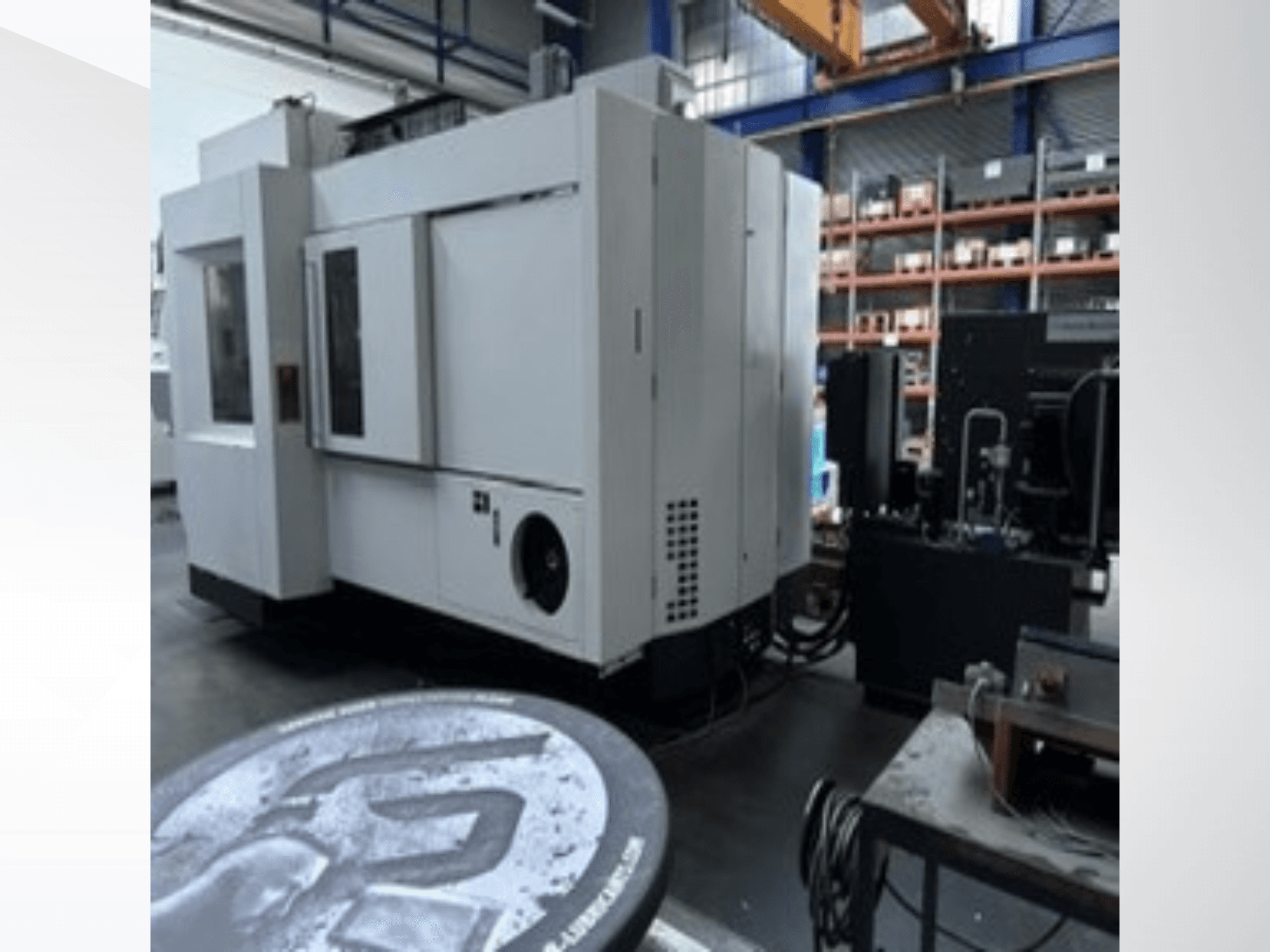 Centre d'usinage universel MIKRON HPM 1350 U blanc dans un atelier, vue de profil montrant le grand panneau de commande et l'environnement industriel.
