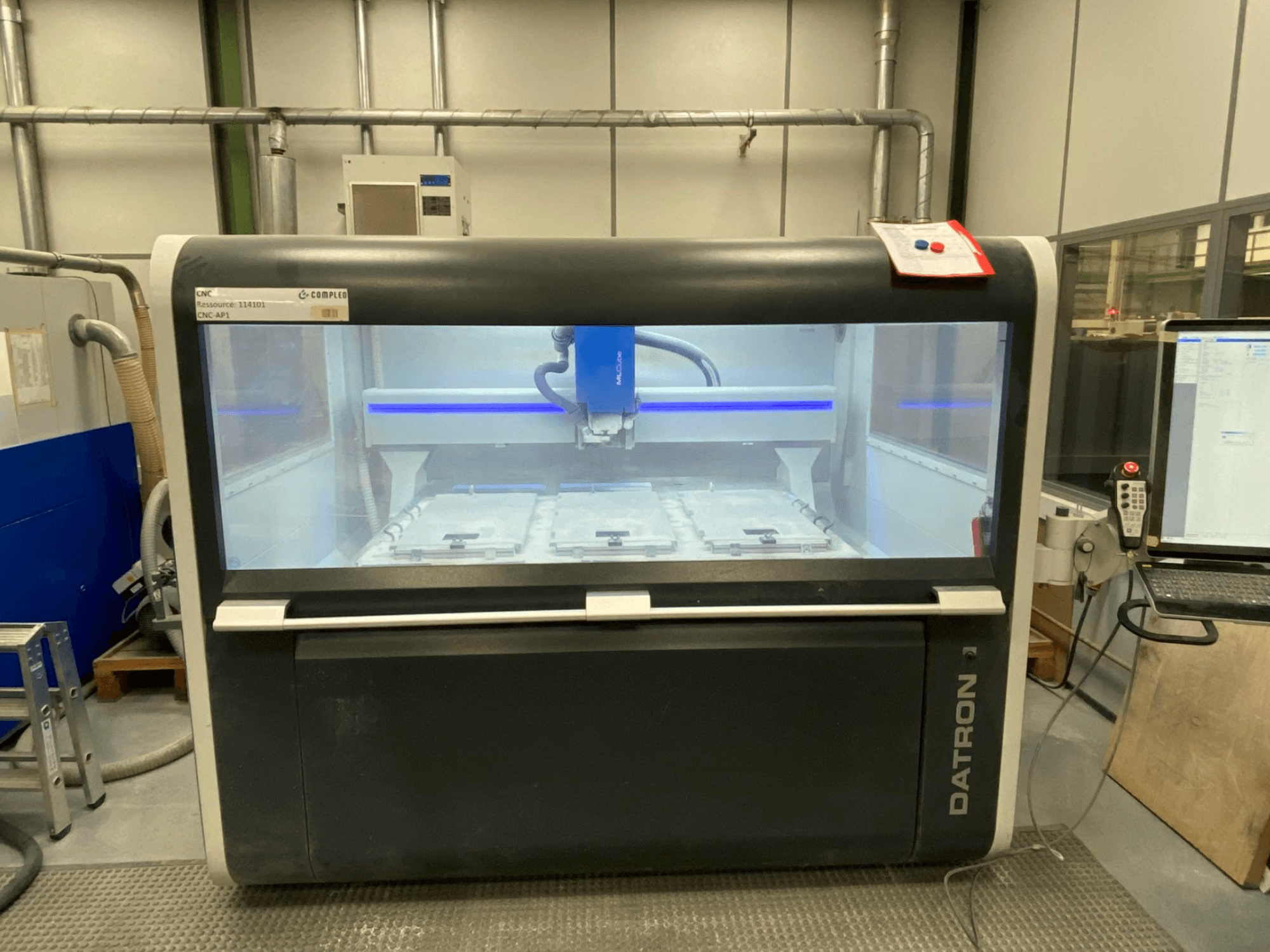 Centre d'usinage vertical Datron MLCube B, vue de face, présentant l'intérieur de la machine et le panneau de commande.