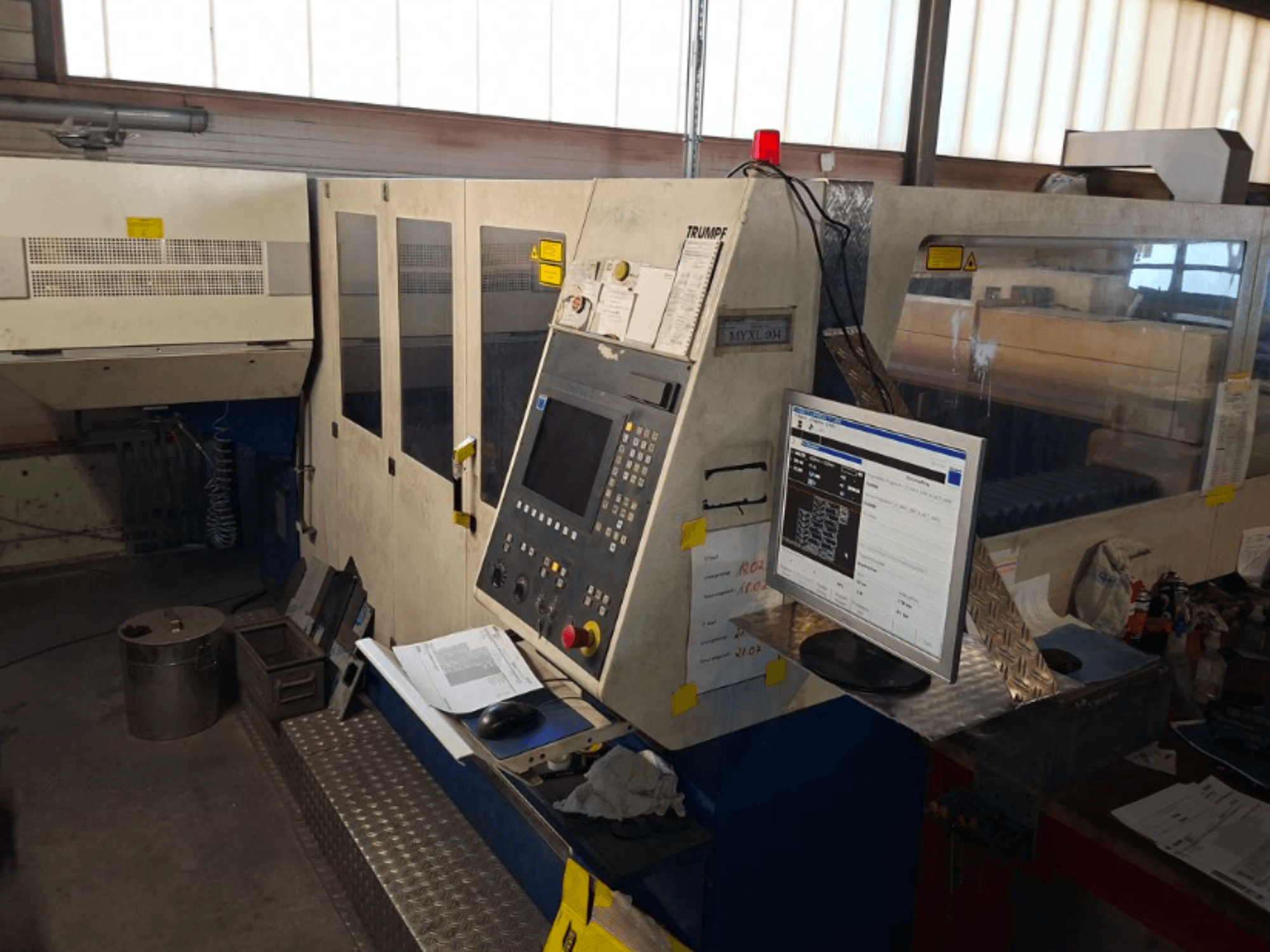 Machine de découpe laser CO2 TRUMPF Trumatic L 4030, vue de face montrant le panneau de commande et l'écran, avec les détails de l'espace de travail visibles.