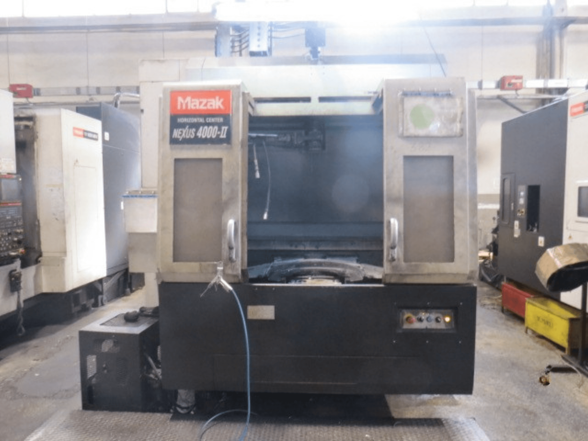 Centre d'usinage horizontal Mazak NEXUS 4000 II, vue de face montrant le panneau de commande, le système d'alimentation en liquide de refroidissement et la zone de travail dégagée.