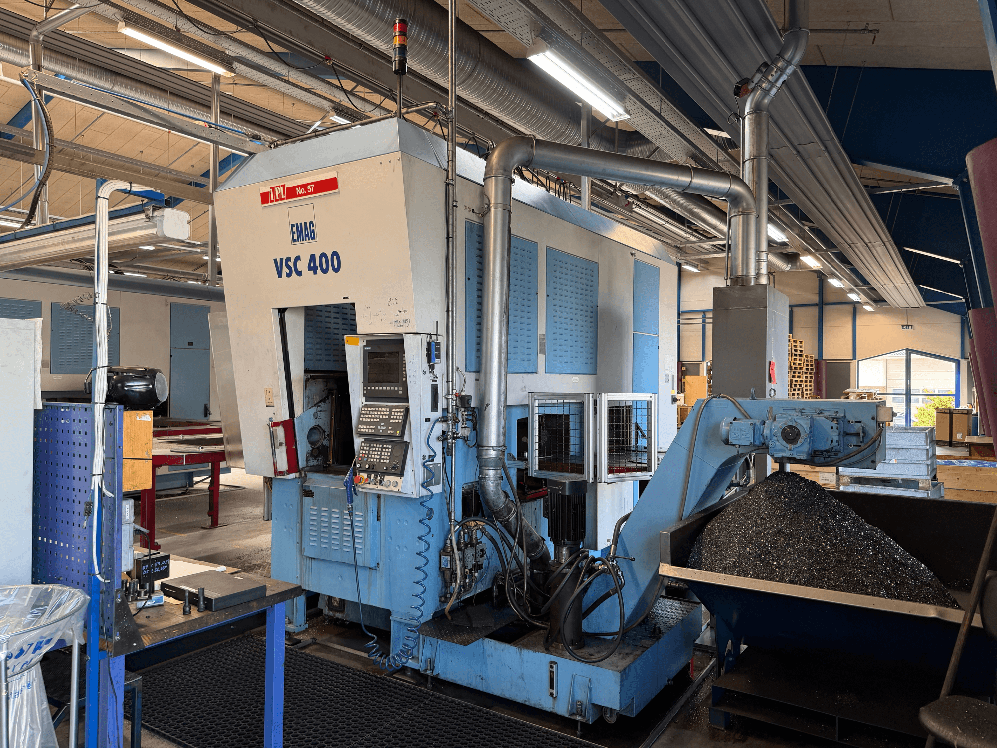 Tour vertical EMAG VSC 400, vue de face, montrant le panneau de commande et le convoyeur à copeaux. Cadre industriel visible.