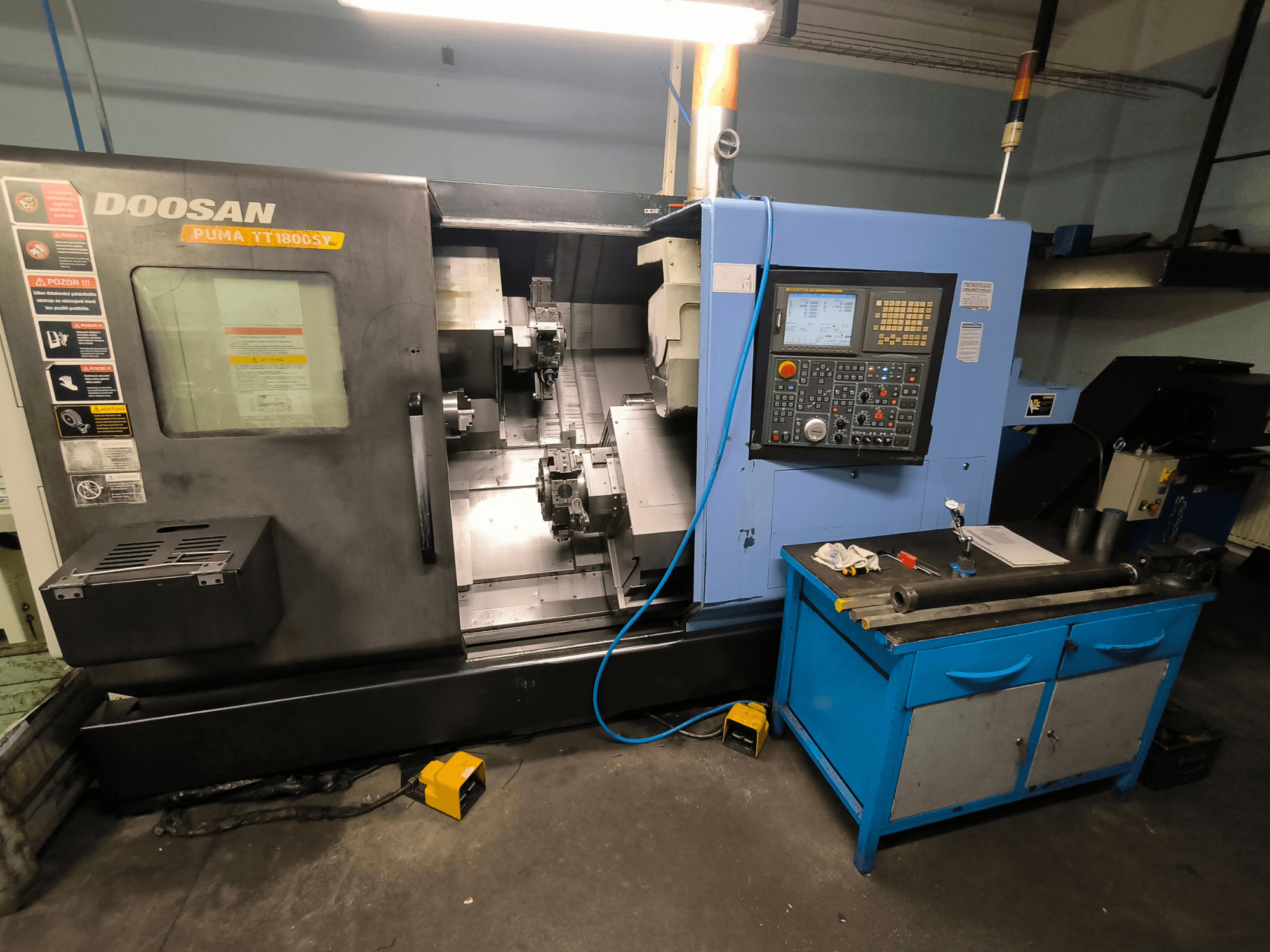 Tour CNC Doosan Puma TT1800SY, vue de face, montrant le panneau de commande, la zone de travail avec les outils et les composants de la machine.