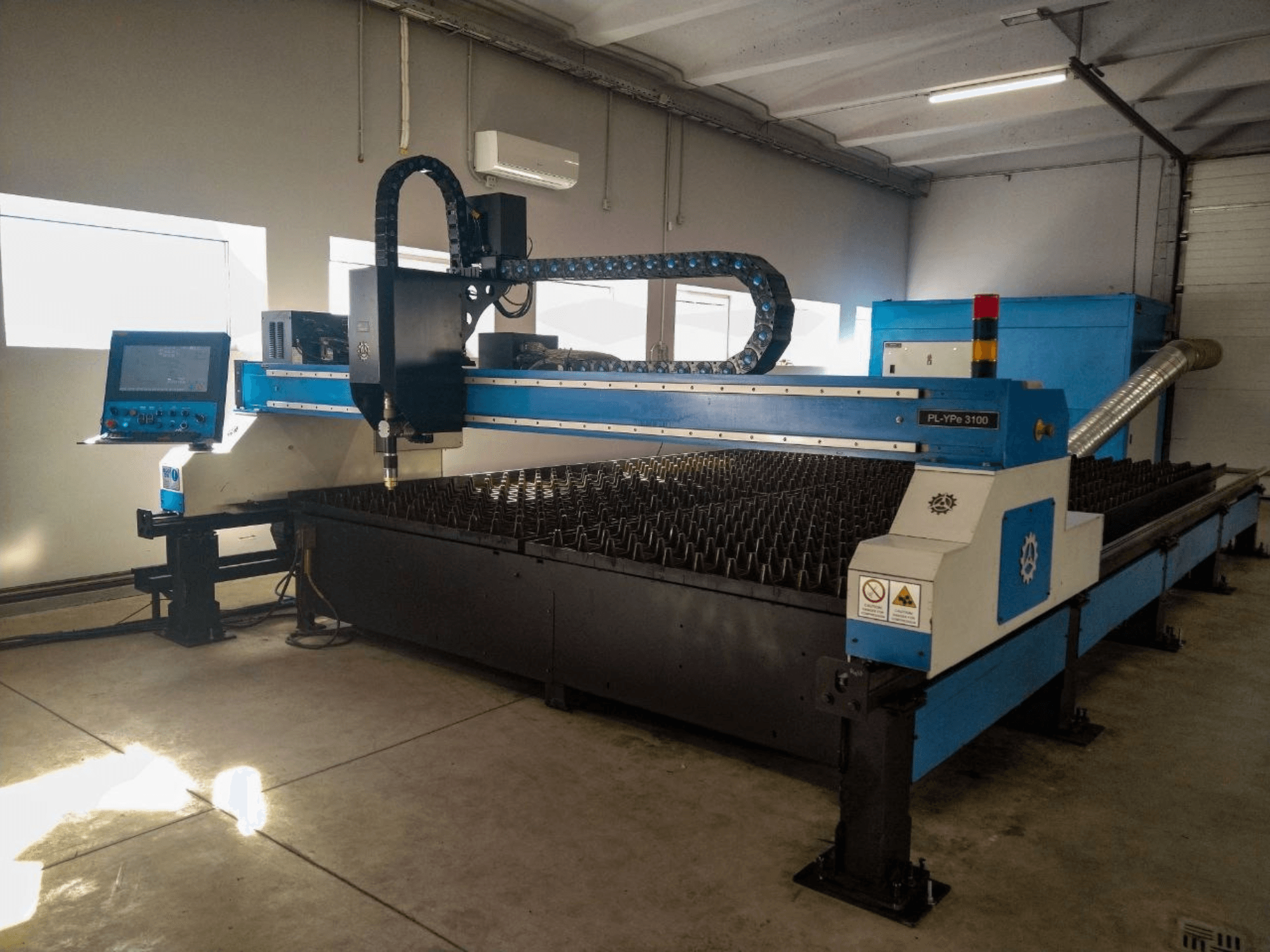 Machine de découpe plasma INANMAK MEKOR PL-YPe 3100, vue de face, comportant un panneau de commande et une table de découpe avec des pointes métalliques surélevées.
