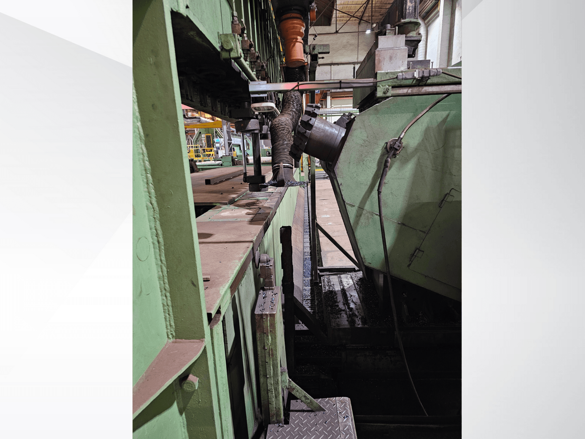 Machine industrielle verte avec vue latérale d'une trémie et d'un mécanisme d'alimentation, mettant en valeur des composants métalliques et une plate-forme.