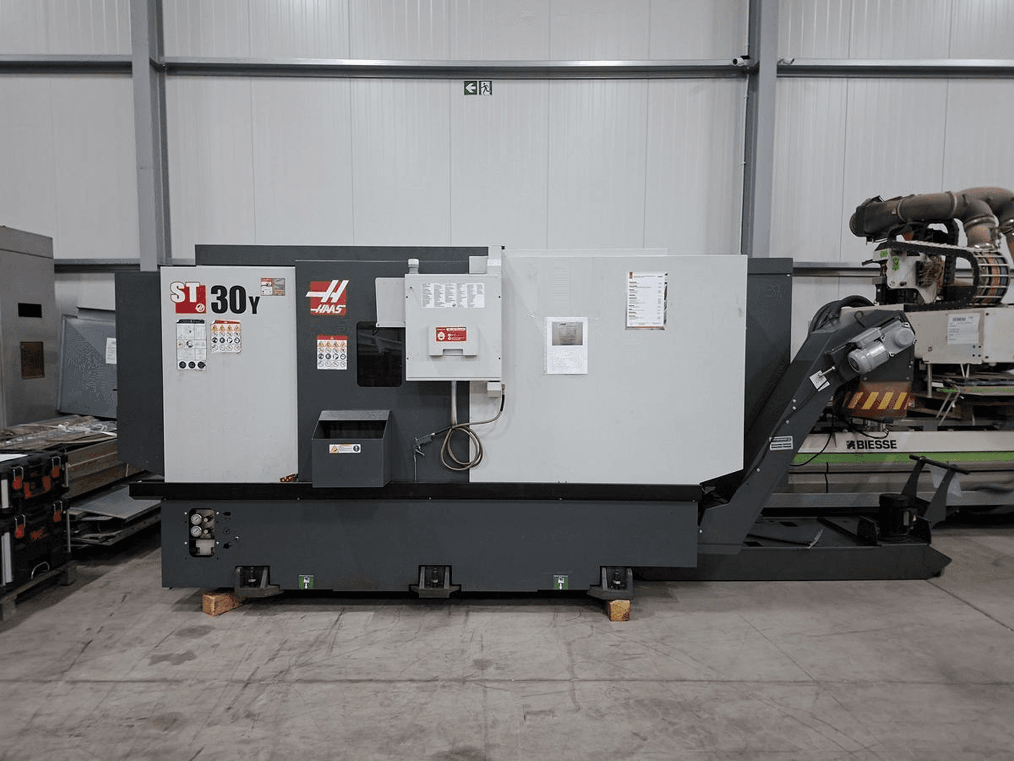 Tour horizontal Haas ST-30Y vu de profil, montrant les commandes, les étiquettes et sa construction robuste dans un atelier spacieux.