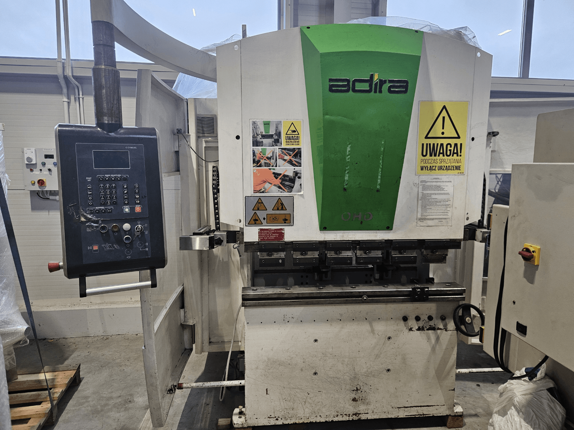 Machine Adira OHD vue de face, comportant un panneau de commande, des avertissements de sécurité et des boutons opérationnels.