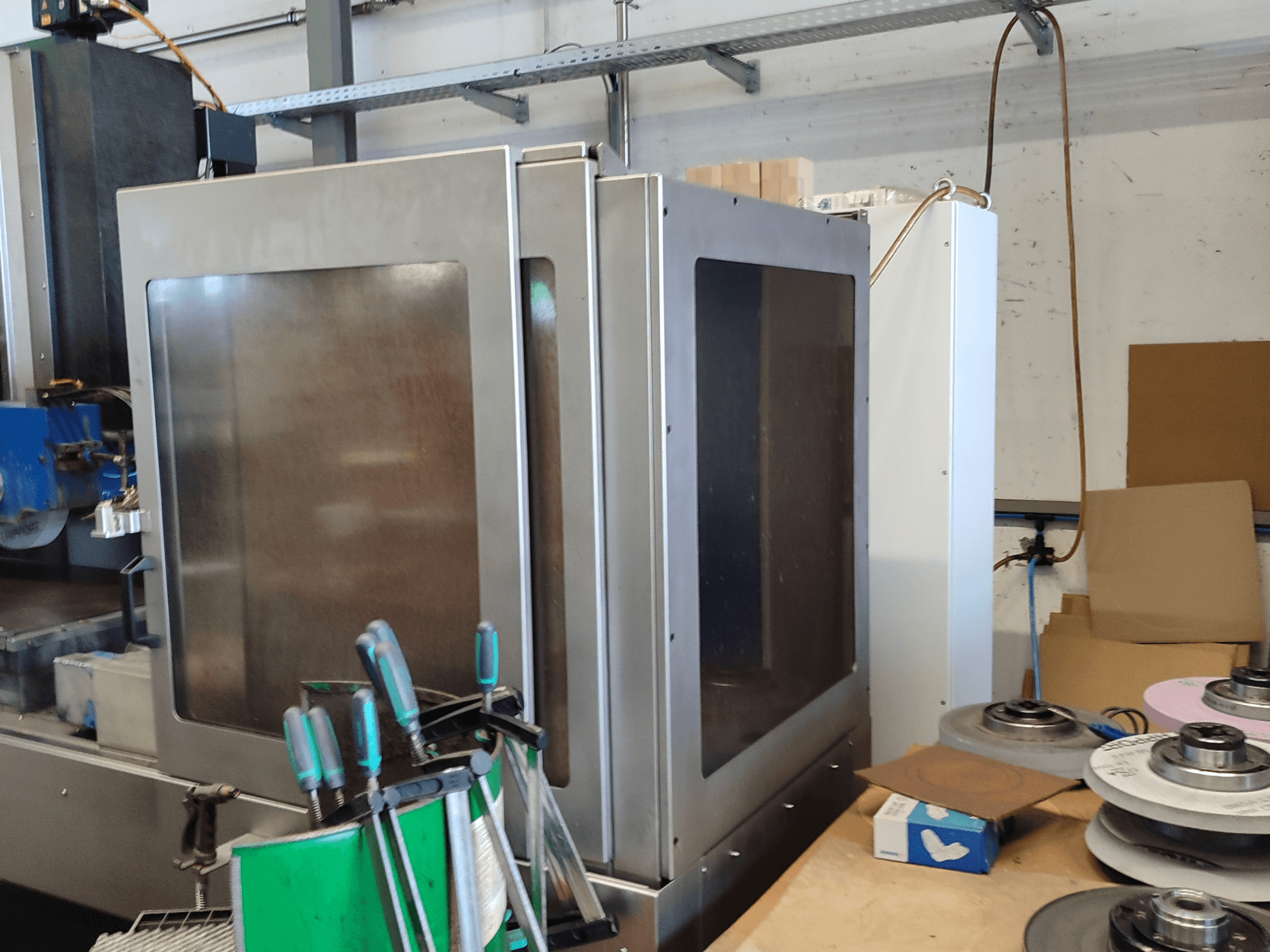 Machine à rectifier les surfaces HEINZ STÖCKEL FD 1560 NC-T, vue de côté montrant le boîtier métallique et les composants de rectification dans un atelier.