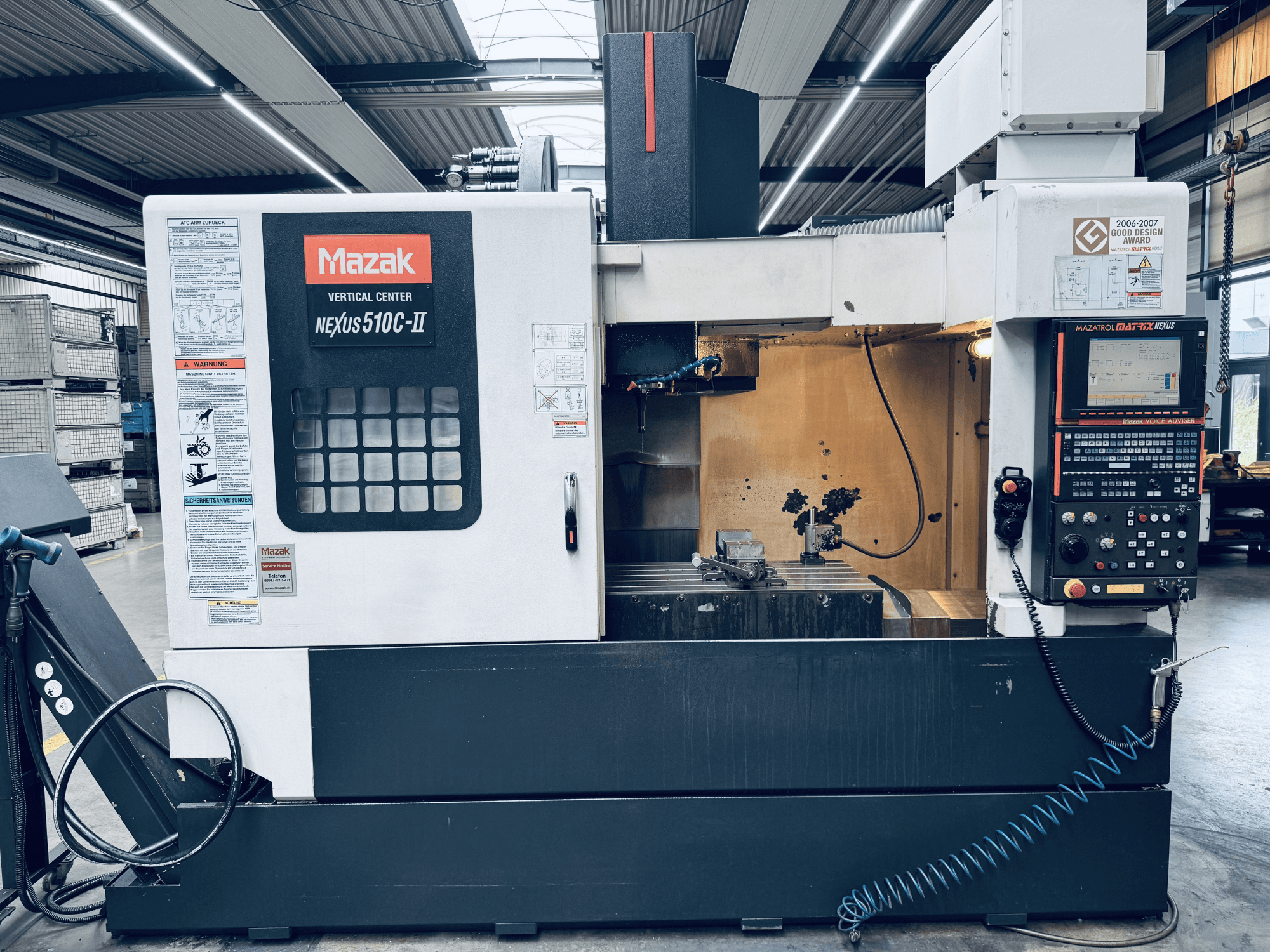 Centre d'usinage vertical Mazak Nexus 510C-II, vue de face, montrant le panneau de commande, la zone de travail et les fonctionnalités opérationnelles dans un atelier.
