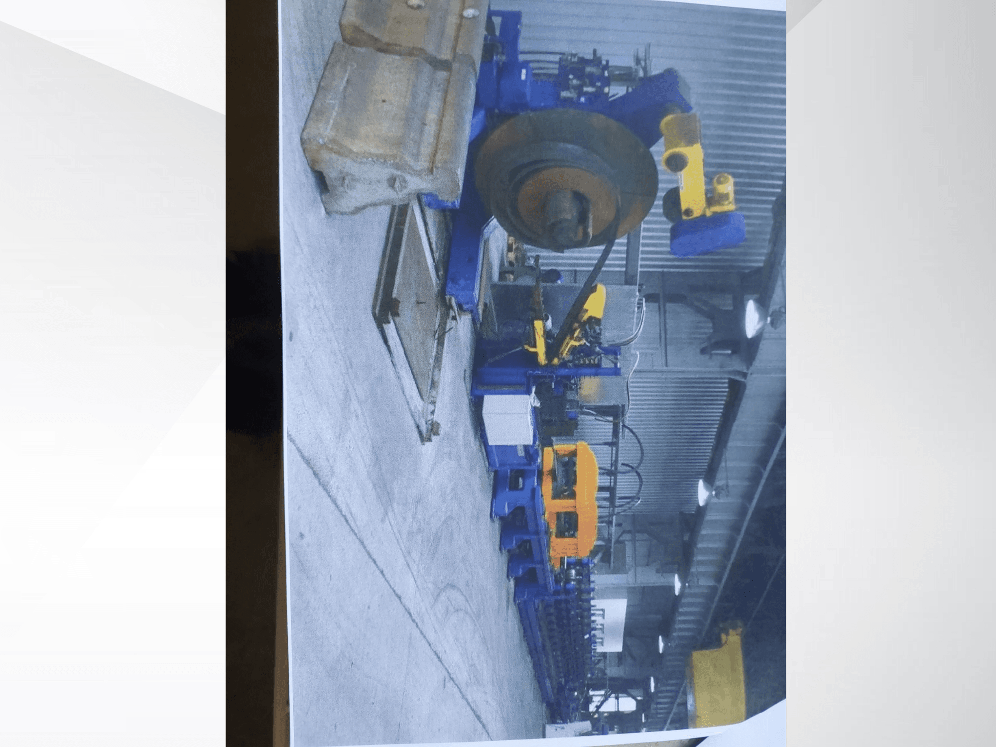 Une cintreuse de profilés Müller Profilierung 3 dans un atelier, mettant en valeur sa structure bleue et ses composants hydrauliques jaunes.