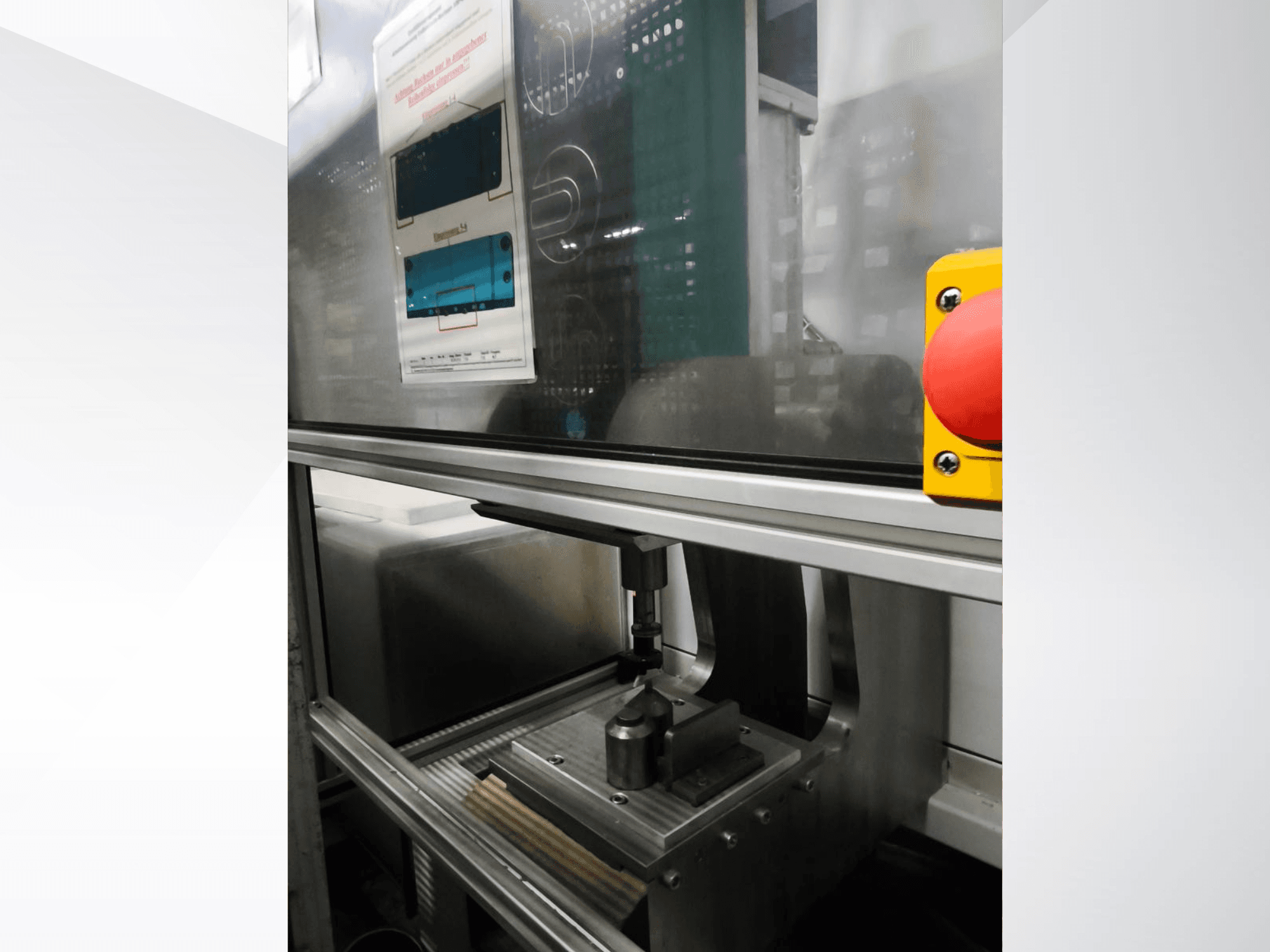 Vue de face de la machine-outil Buchsenpresse d'EMS Automation, montrant le mécanisme de pressage et le bouton de sécurité.