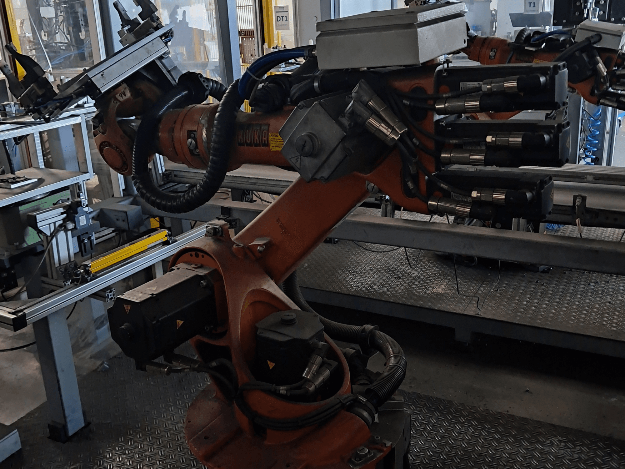 Bras robotisé KUKA KR 16-2 équipé d'un contrôleur KRC 4, vu de profil, mettant en évidence ses articulations et ses raccords hydrauliques.