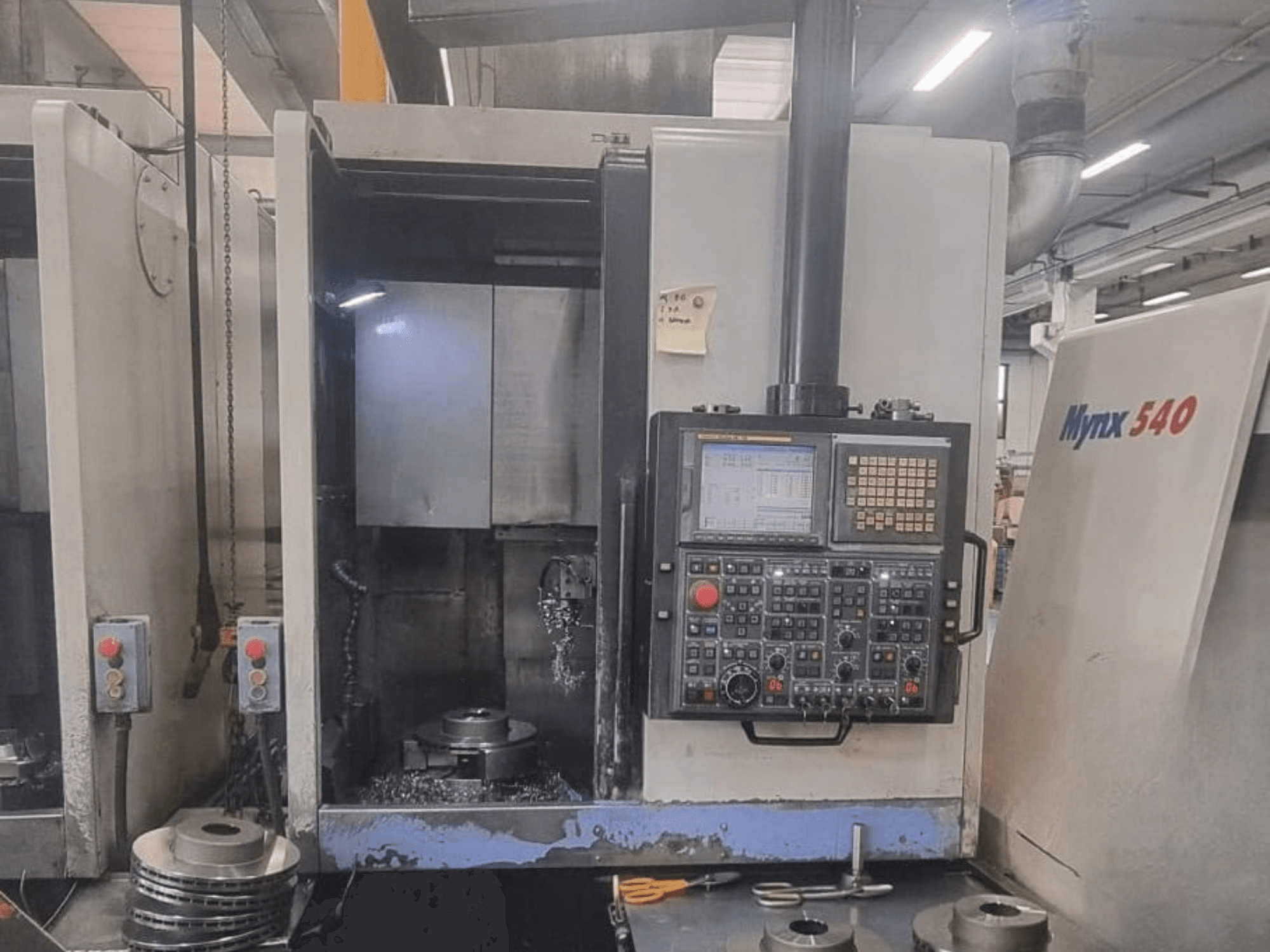 Vue de face d'un tour vertical DOOSAN PUMA V400-2SP, montrant le panneau de commande et la mise en place de la pièce à usiner à l'intérieur de la machine.