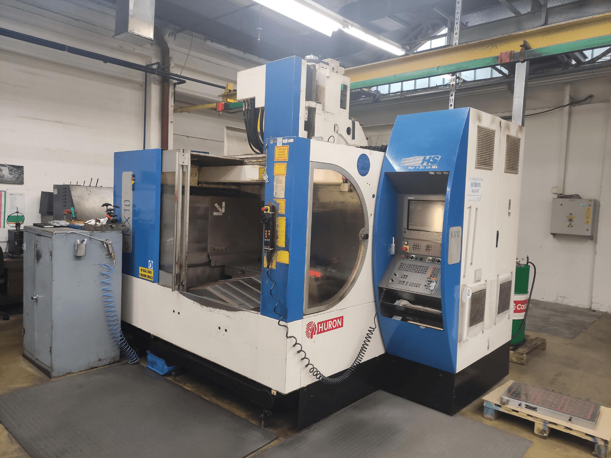 Machine CNC HURON KX10 dans un atelier, vue de face, avec panneau de commande et grande ouverture pour l'usinage.