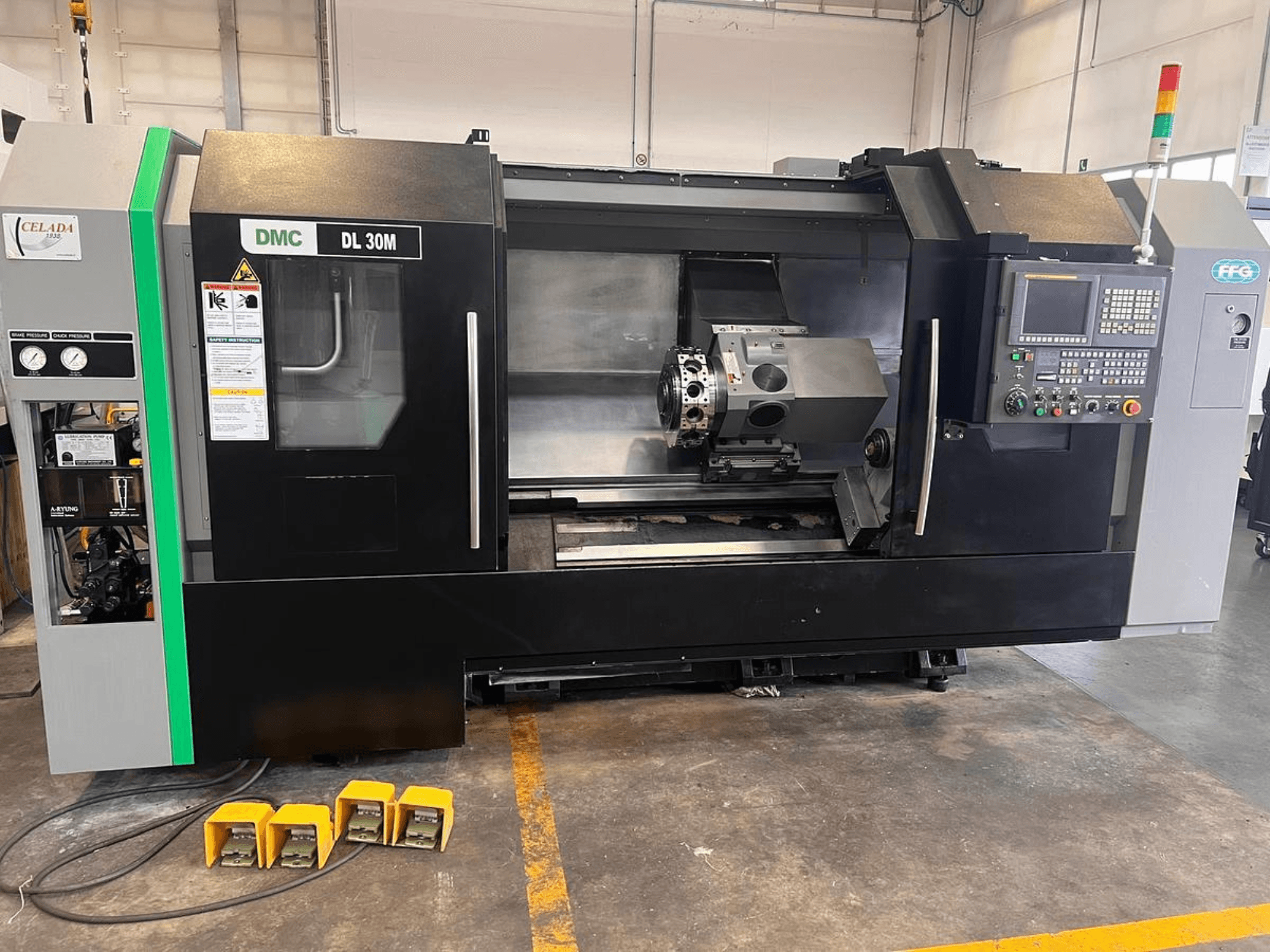 Machine CNC DMC DL 30M avec une vue latérale montrant les commandes, la broche et les trois pédales au sol.