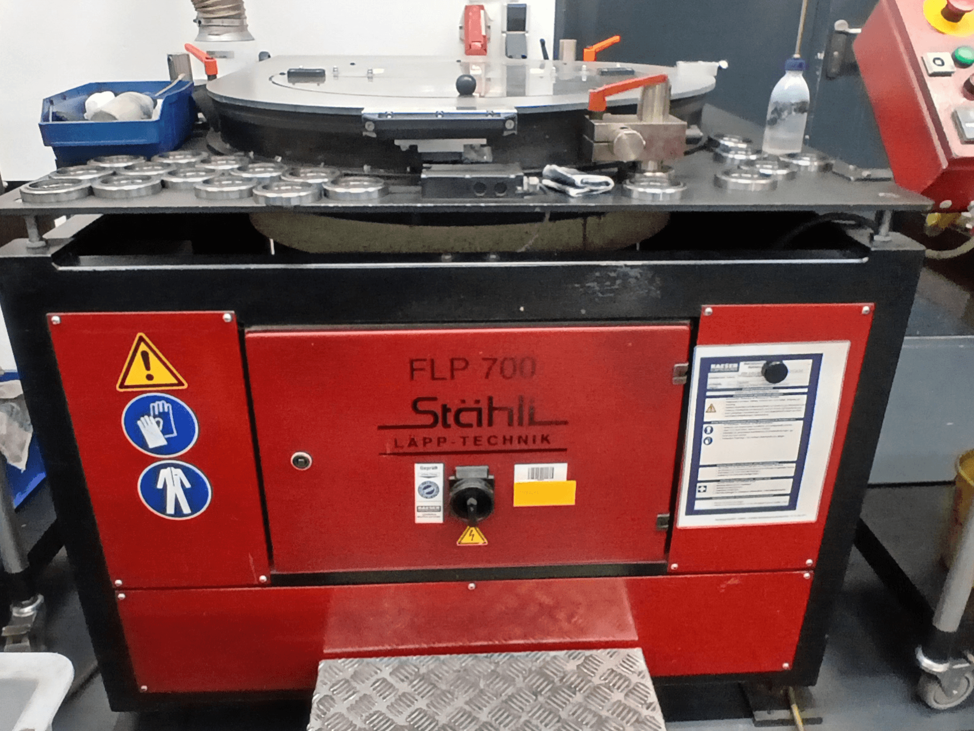 Machine-outil STAHLI FLP 700, vue de face, comportant des commandes opérationnelles, des avertissements de sécurité et des composants sur une surface métallique.