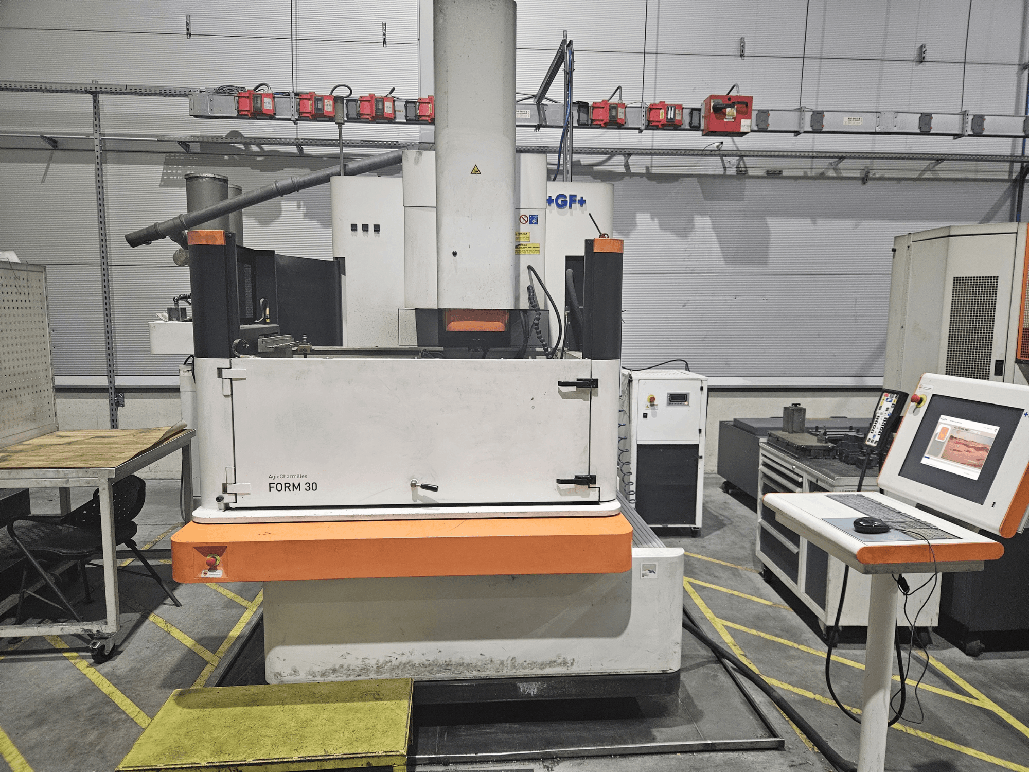 Machine ApeqChemicals FORM 30 dans un atelier, vue de face avec le panneau de commande et la table de travail sur le côté.