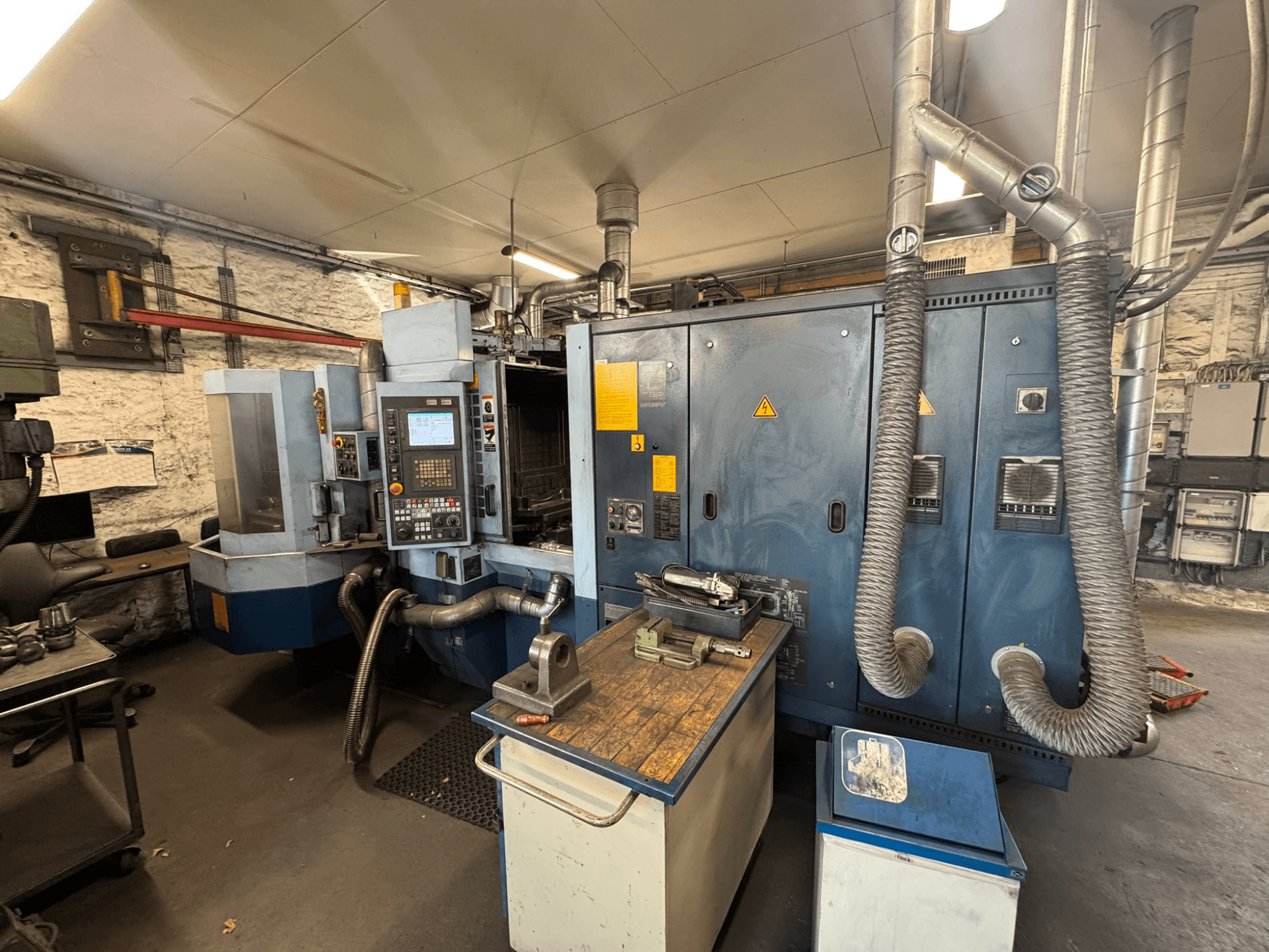 Centre d'usinage horizontal Matsuura H.PLUS-300 dans un atelier, vue de face, montrant le panneau de commande et la table de travail.