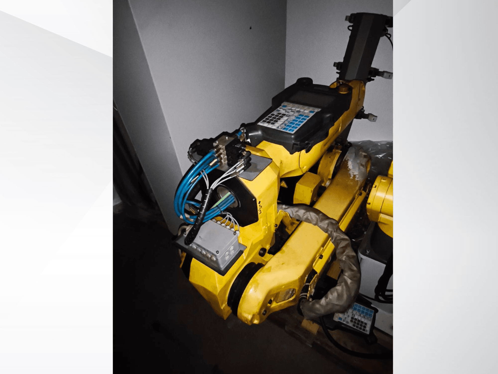 Bras robotique FANUC M-20iA en vue latérale, montrant le corps jaune, le panneau de commande et le câblage connecté.