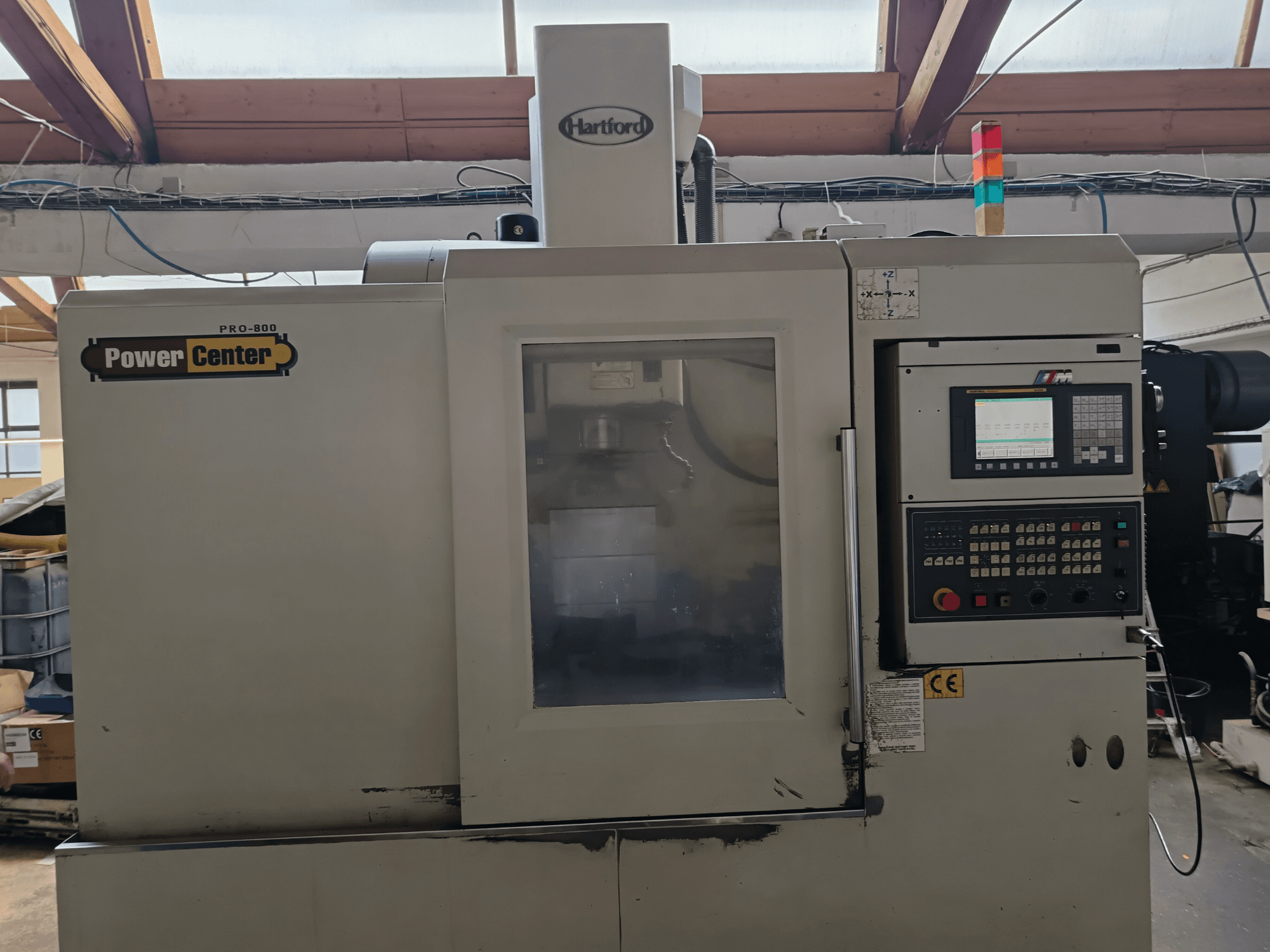 Centre d'usinage vertical HARTFORD PRO-800A, vue de face, montrant le panneau de commande et la vitre permettant de voir l'intérieur.
