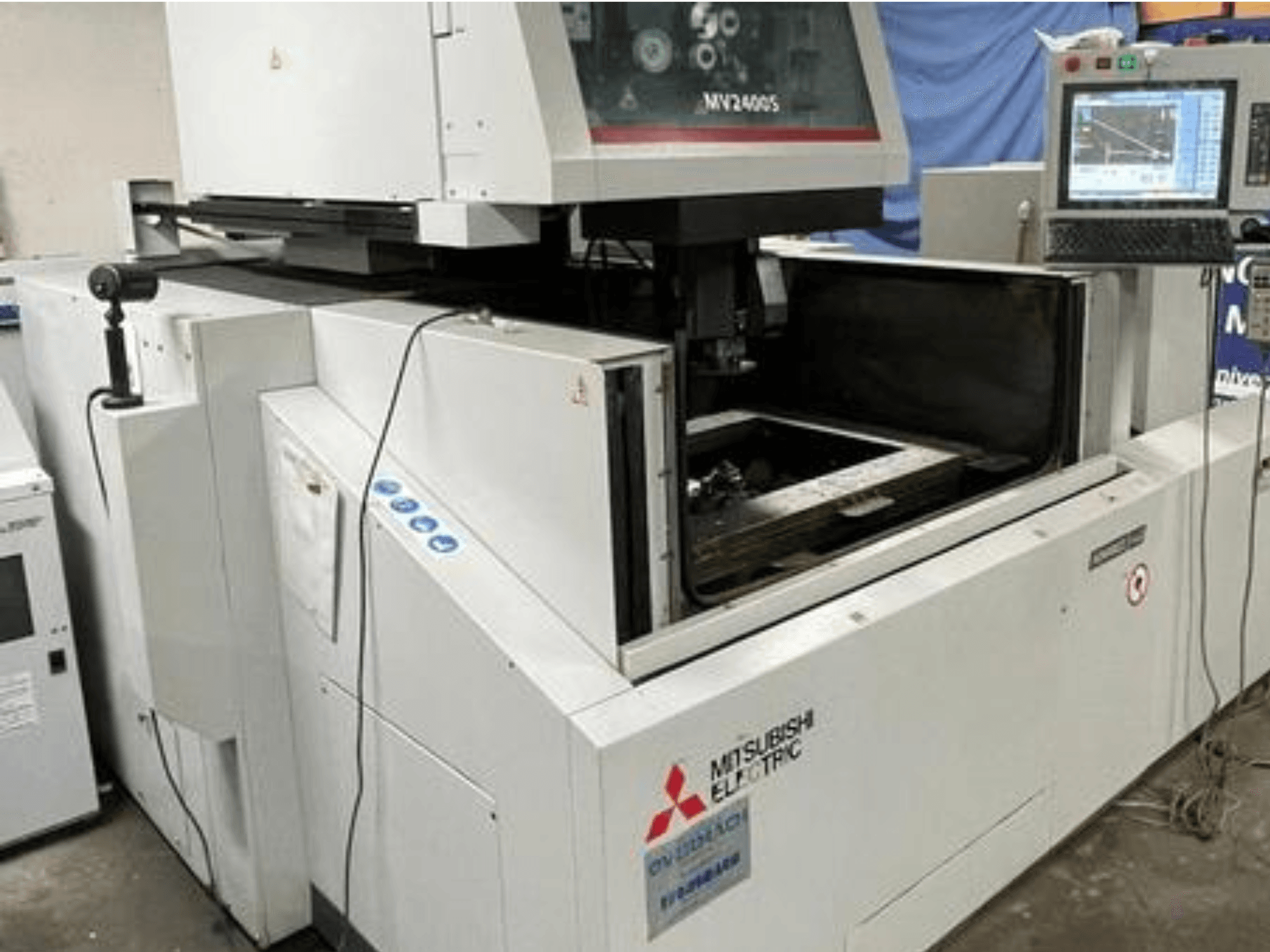 Machine d'électroérosion à fil MV2400S de Mitsubishi Electric, vue de face, montrant le panneau de commande et la zone de travail ouverte.