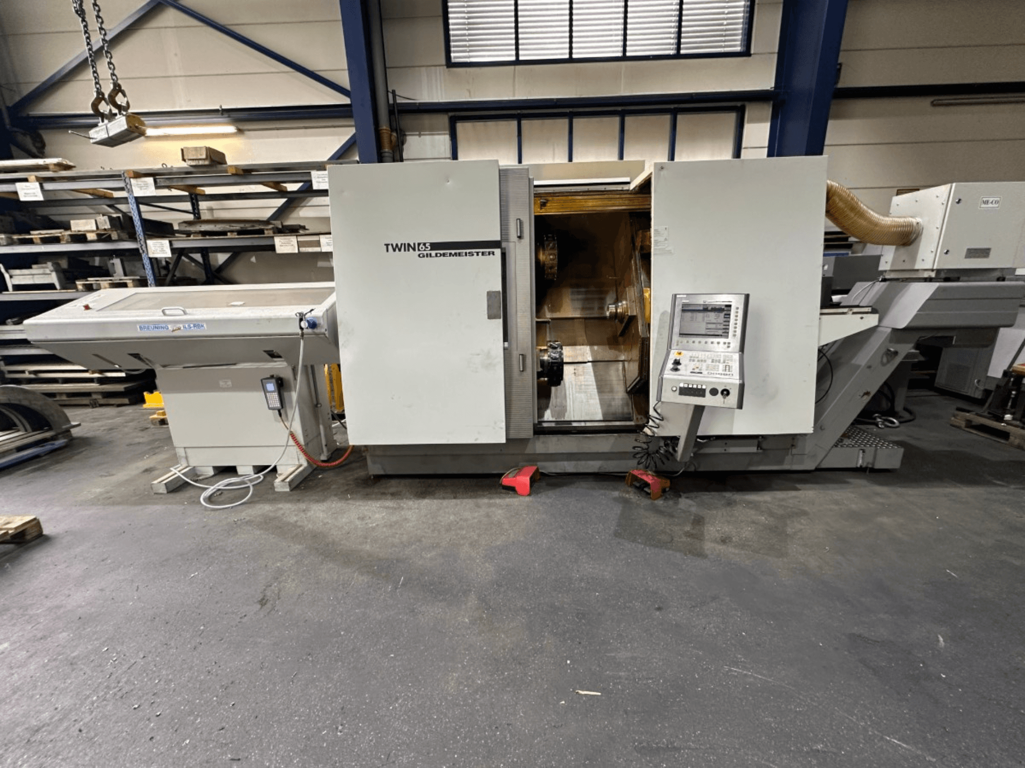 Tour horizontal Gildemeister TWIN 65, vue de face ; panneau de commande et intérieur visible pour l'usinage des pièces.