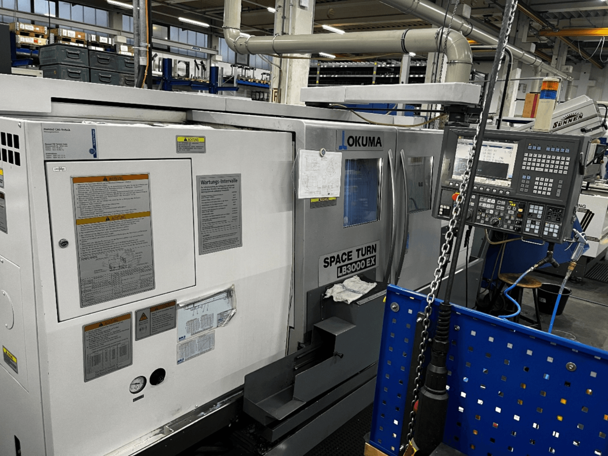 Tour horizontal Okuma LB3000 EX, vue de face, avec panneau de commande et informations de sécurité sur le côté.