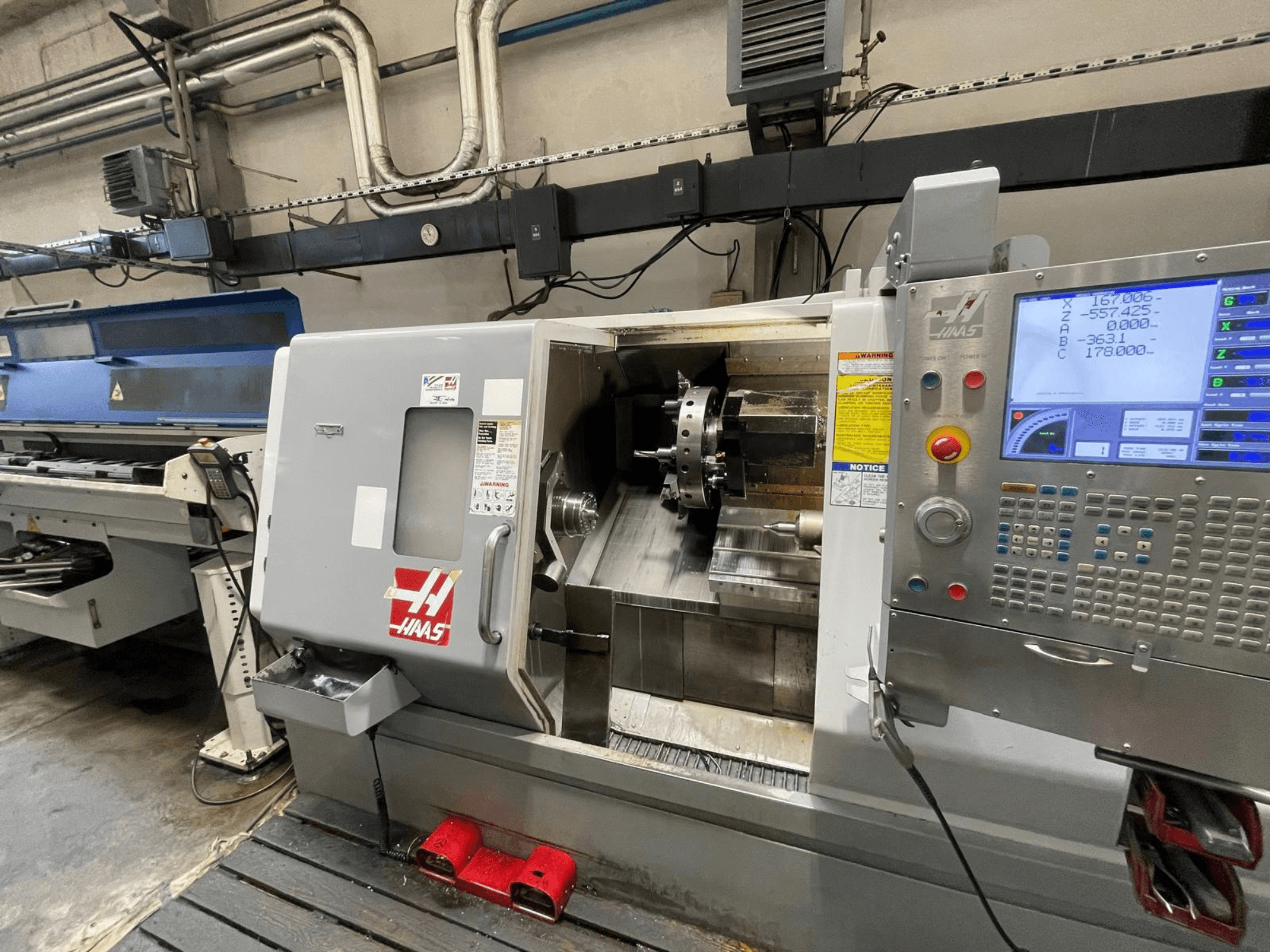 Le tour horizontal Haas SL-30THE dans un atelier, doté d'un panneau de commande numérique et d'une zone de travail dégagée.