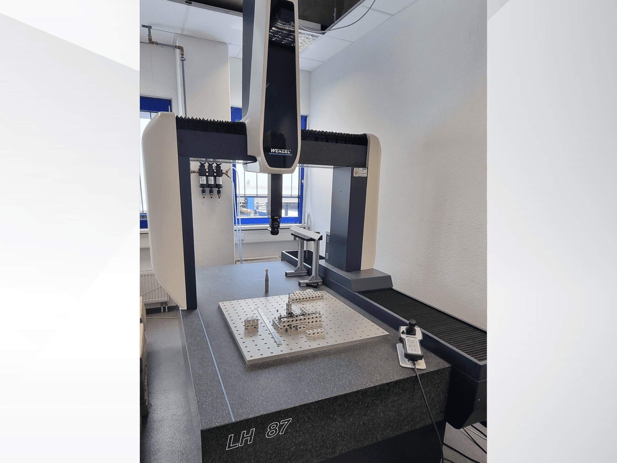 Machine à mesurer tridimensionnelle (CMM) Wenzel LH 87 dans un laboratoire, vue de face avec la sonde de mesure posée sur une plaque de précision et le contrôleur numérique visible.