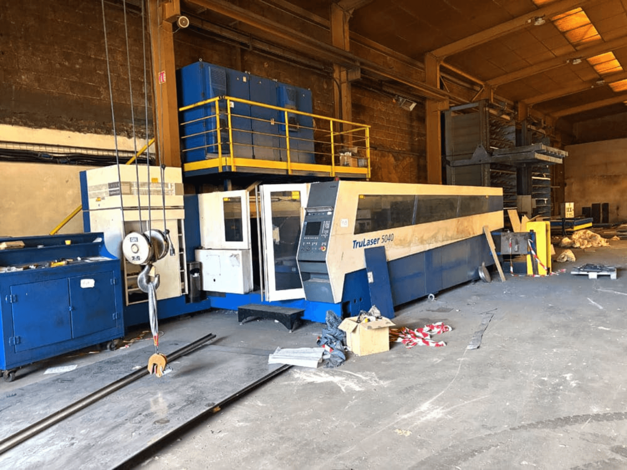 Machine de découpe au laser CO₂ de TRUMPF, modèle TRULASER 5040, photographiée dans un atelier, vue de face en oblique avec un arrière-plan encombré.