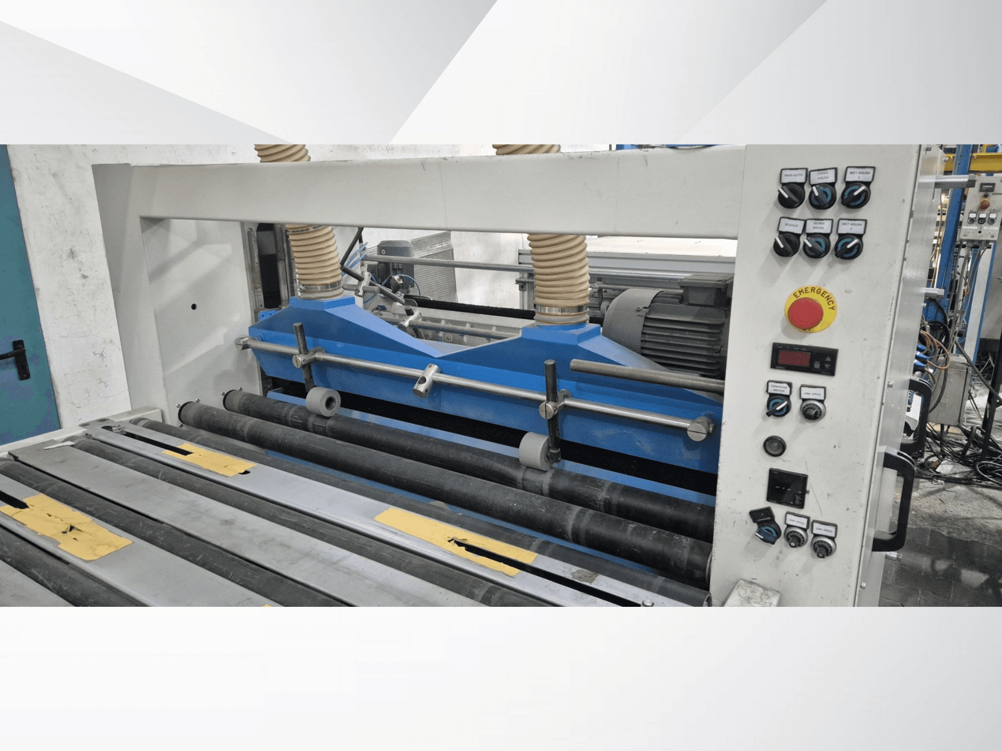 Machine à rouler industrielle à composants bleus, vue de face, avec panneau de commande et bouton d'arrêt d'urgence.