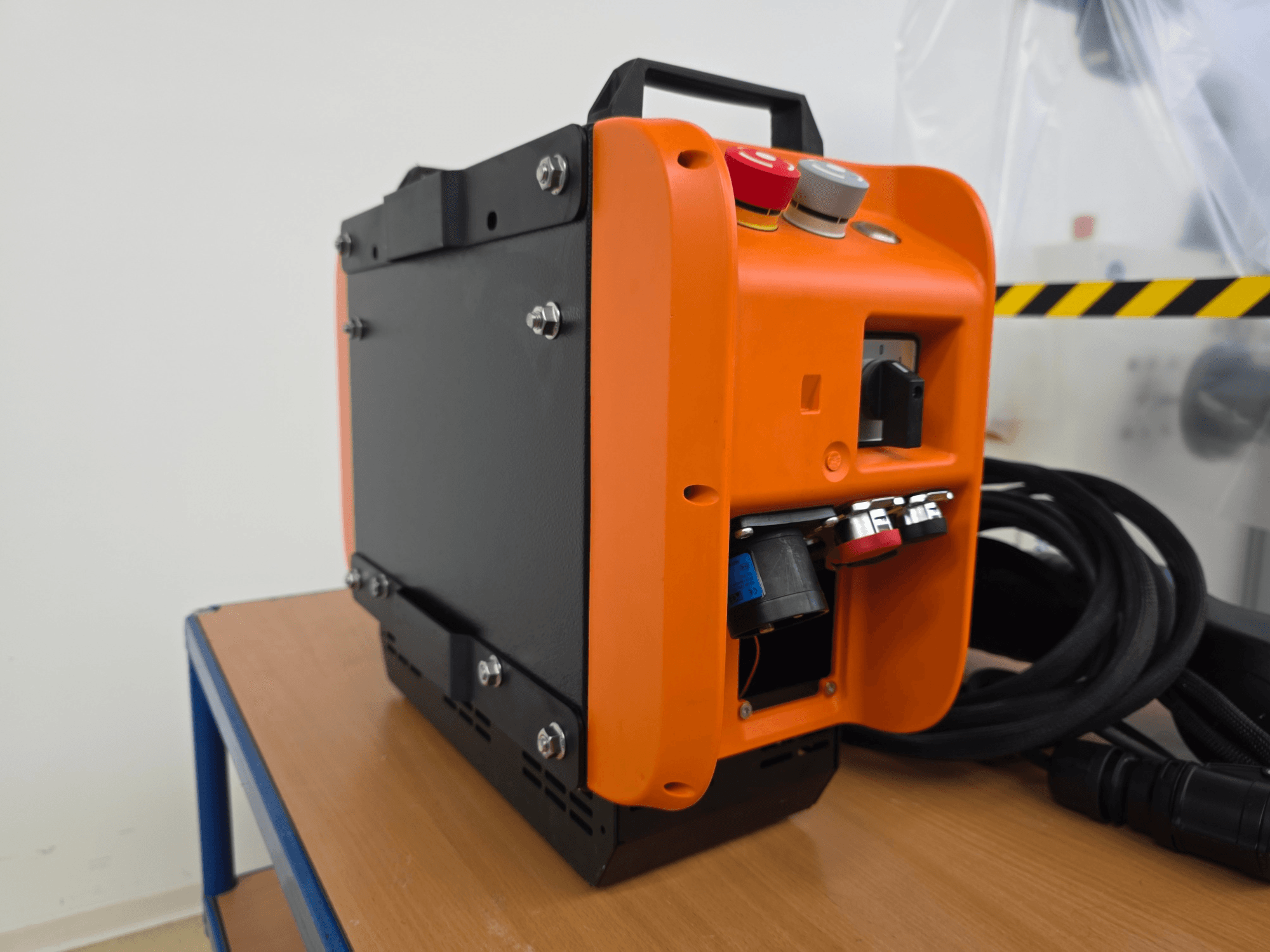 Contrôleur de bras robotique KASSOW ROBOTS KR1205, vue latérale montrant le design orange et noir, les ports d'entrée/sortie et les câbles.