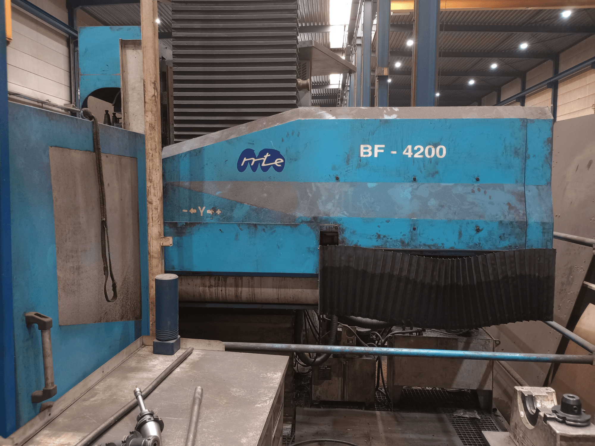 Fraiseuse à banc MTE BF 4200, vue de profil, montrant la carrosserie bleue et les composants détaillés de la machine dans un atelier.