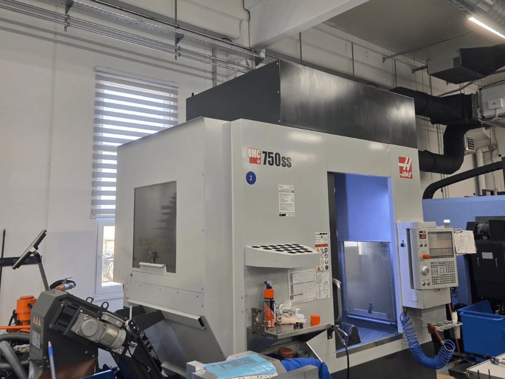 Centre d'usinage vertical Haas UMC-750SS, vue de face, avec panneau de commande et accès dégagé à la zone d'usinage.