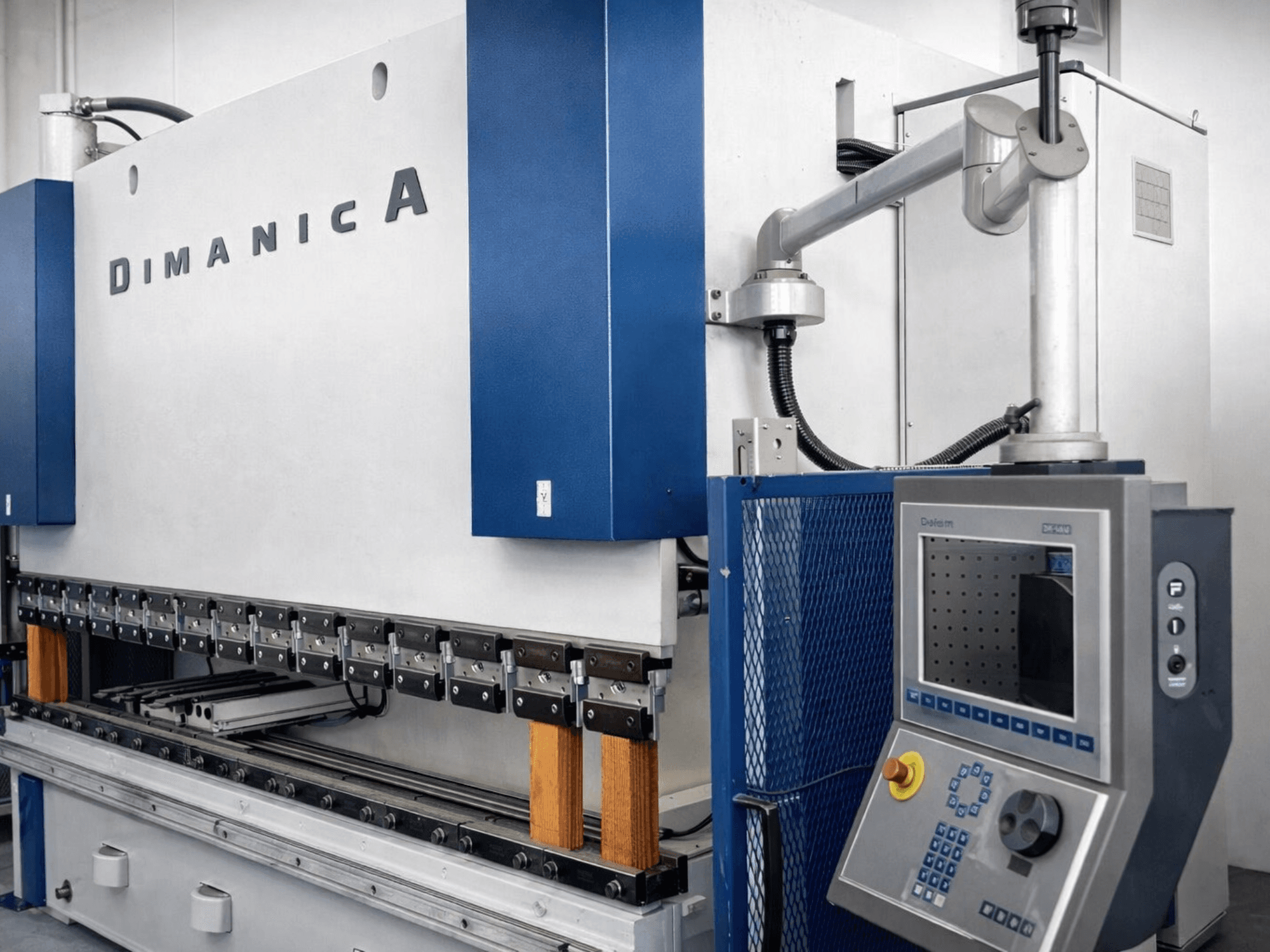 Presse plieuse DINAMICA 3000x100 par Warcom, vue latérale montrant le panneau de contrôle et les outils de pliage pour la fabrication de métal.