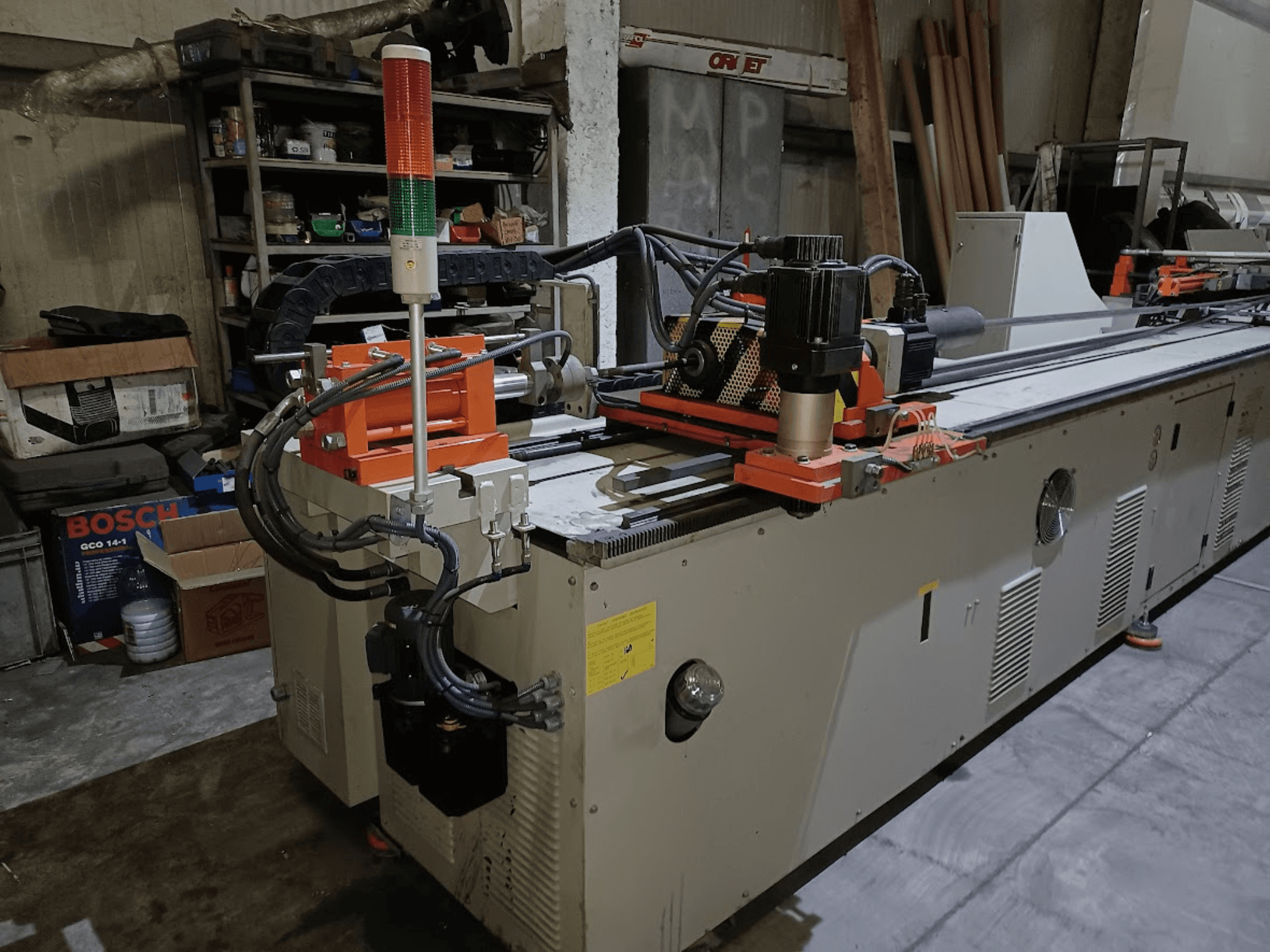 Plieuse CANSA CNC 51 R1, vue de profil, montrant le panneau de commande, le moteur et les voyants lumineux dans un atelier.