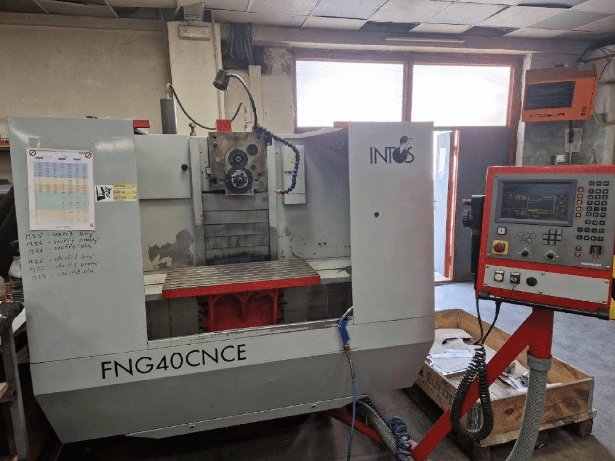 Machine INTOS FNG40CNC, vue de face, avec panneau de commande, éléments opérationnels et table de travail en métal. Idéale pour l'usinage.
