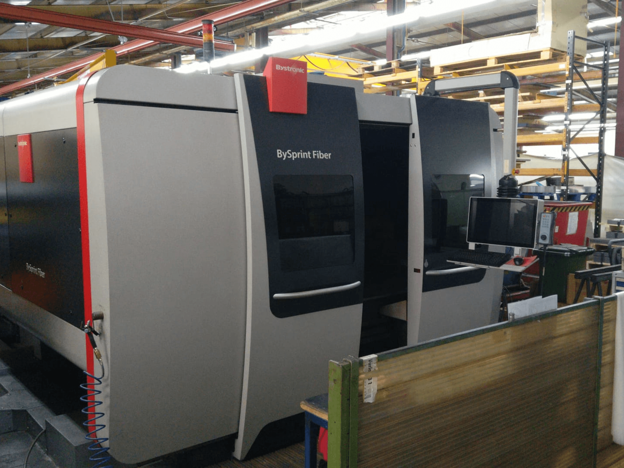 Découpeuse laser à fibre Bystronic BySprint, vue de face avec panneau de commande, détails visibles : deux portes et un moniteur sur le côté.
