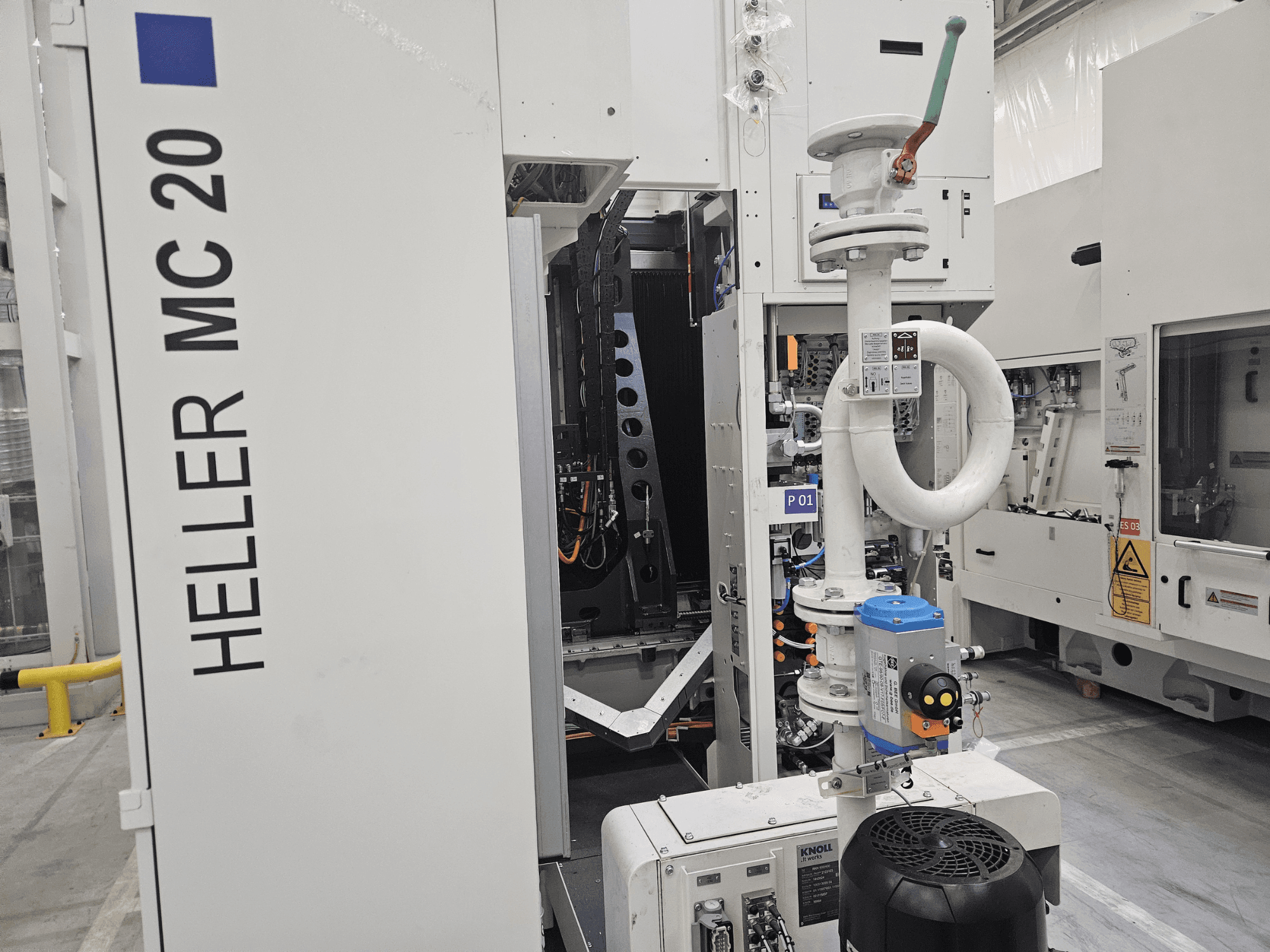 Machine Heller MC 20 dans une usine, montrant le panneau de commande et les composants mécaniques d'une vue latérale.