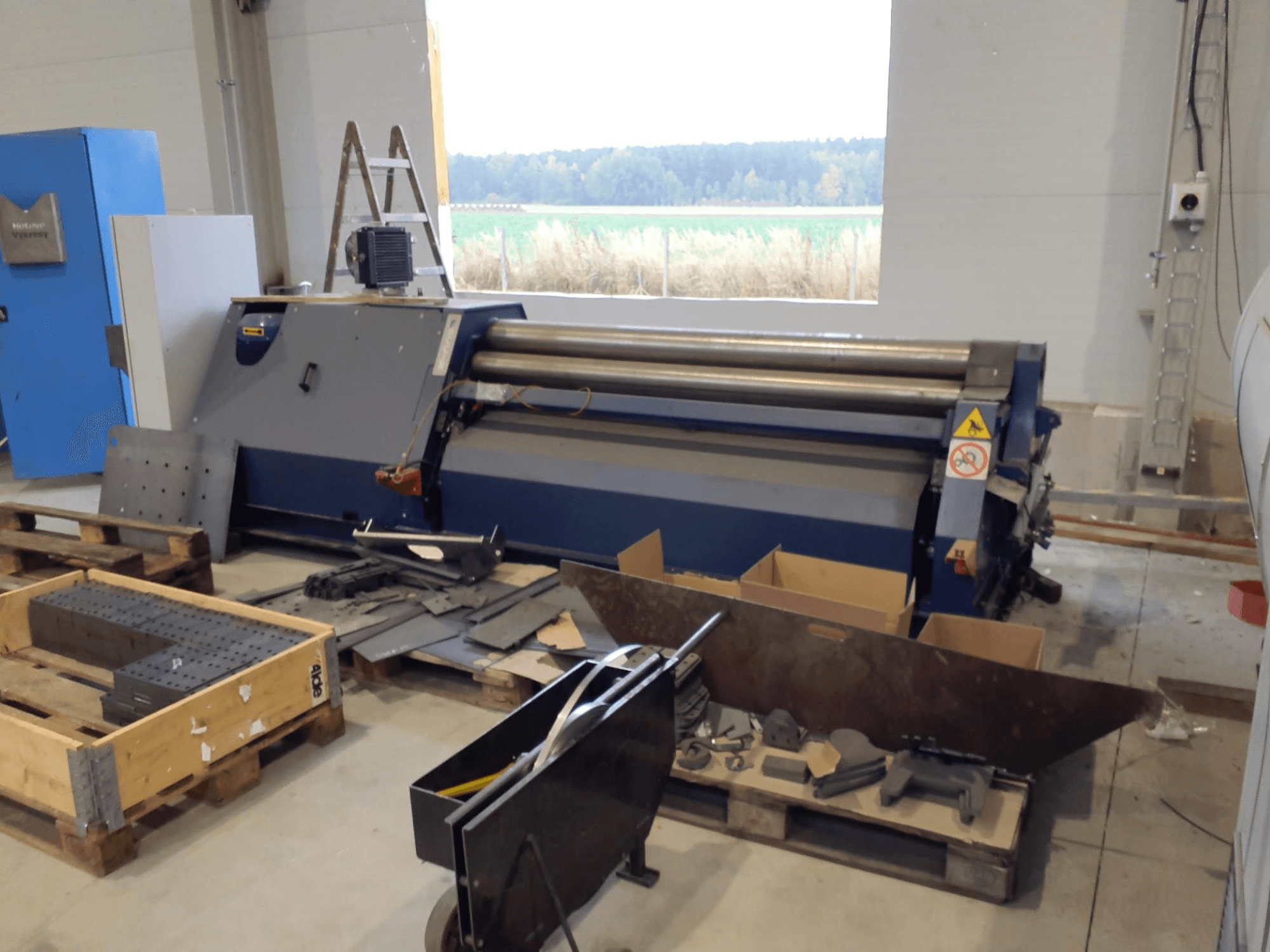 FACCIN 4HEL-2017 Machine à laminer les tôles dans un atelier, vue de face avec des pièces métalliques et des outils éparpillés.