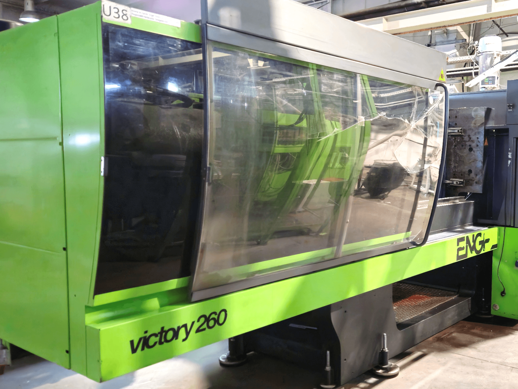 Machine de moulage par injection ENG victory 260, vue de face ; elle se caractérise par un extérieur vert et un grand panneau de verre pour la visibilité.