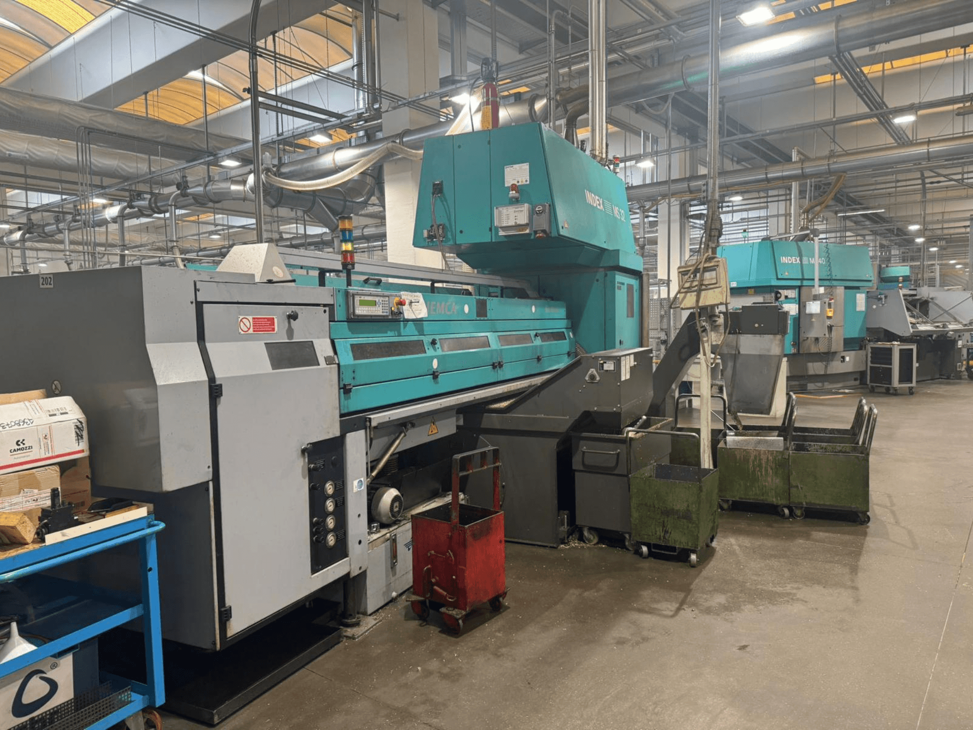 Tour multibroche INDEX MS32C, vue de face montrant les commandes et la zone opérationnelle dans un atelier.