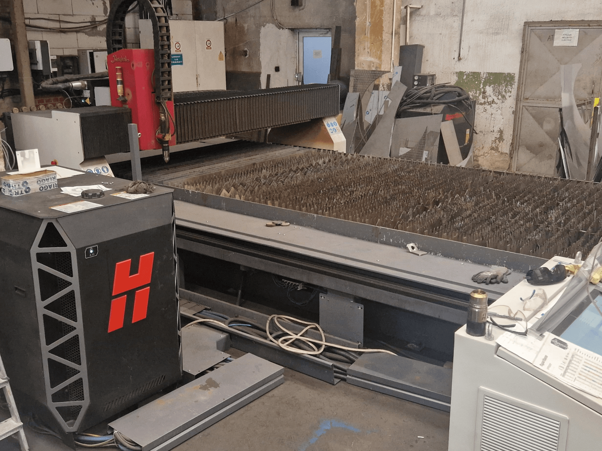 Machine de découpe au plasma Baykal BPS 2004 dans un atelier, vue de face montrant le plateau de découpe et le panneau de commande.