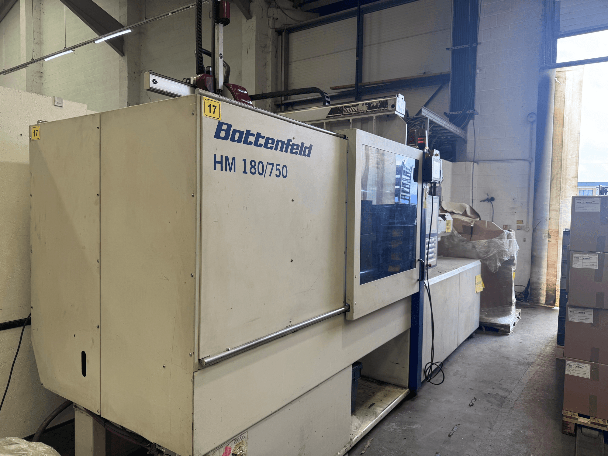 Machine de moulage par injection hydraulique Battenfeld HM150750 vue de l'avant, montrant le panneau de commande et les installations environnantes.