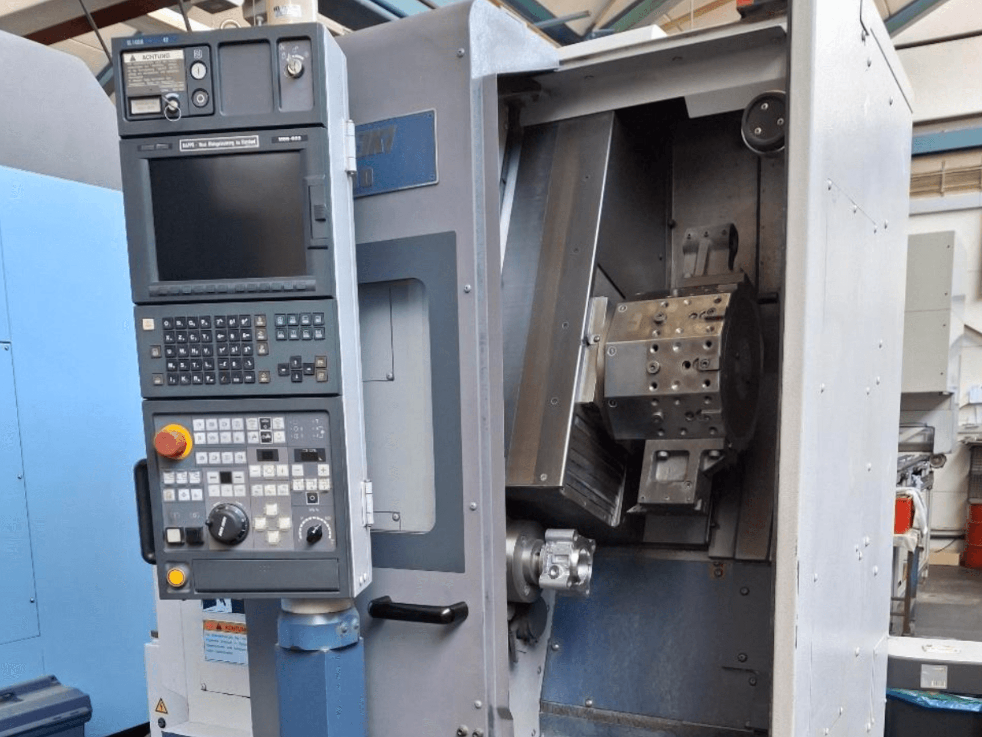 Vue de face du tour horizontal MORI SEIKI SL 1000, avec panneau de commande et mécanisme interne détaillé.