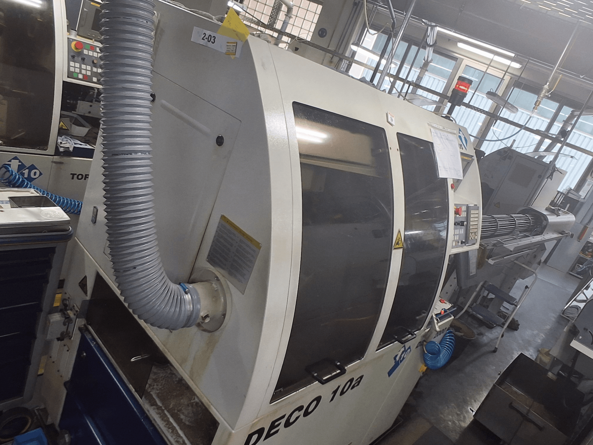 Machine DECO 10a vue de face ; elle comporte un grand panneau de commande, des conduits et des autocollants opérationnels visibles.