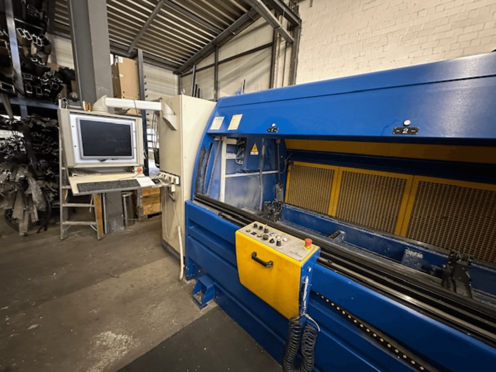 Vue de face du SCHÜCO Profilbearbeitungscenter 299 650, un centre d'usinage universel avec commandes et poste de travail informatisé.